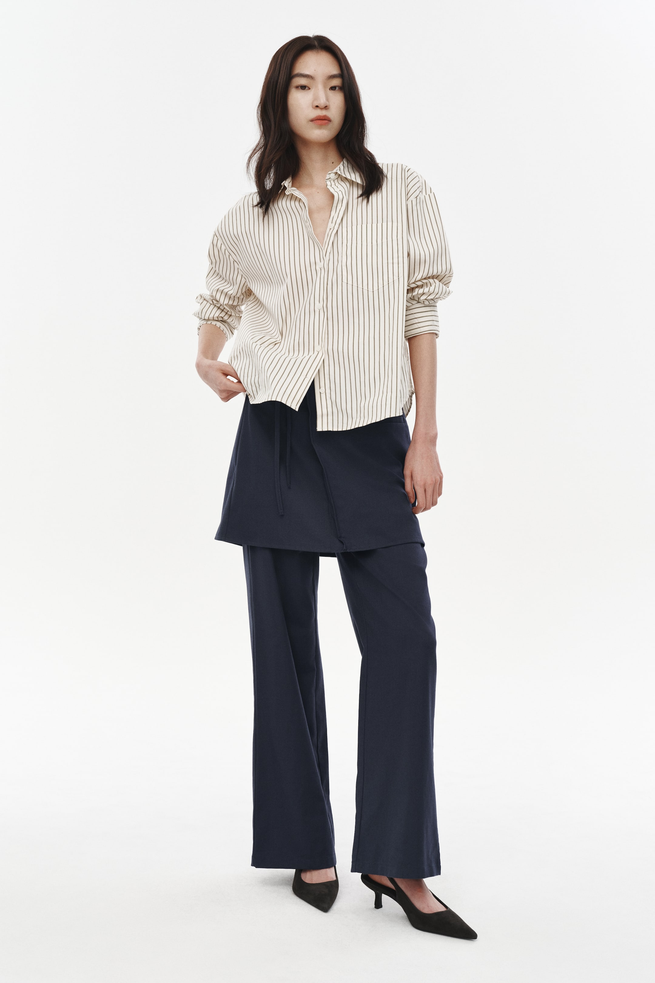 이미지 확대 보기: 네이비 블루 와이드 레그 팬츠가 정면에서 촬영된 사진으로, 앞 허리 부분에 보이는 드로스트링과 짧은 랩 스타일 오버레이가 특징입니다.