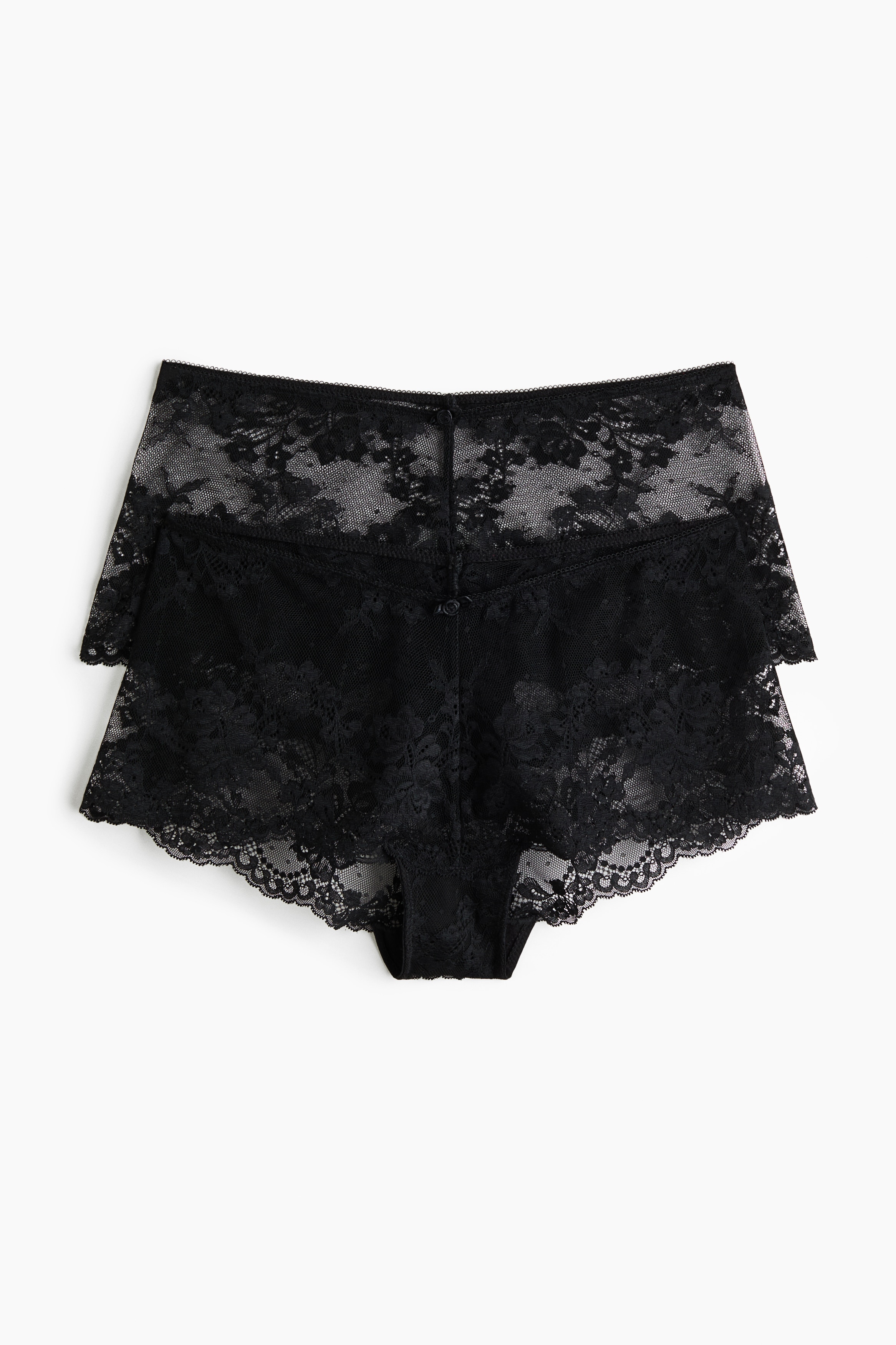 Il modello indossa uno slip in pizzo nero con vita bassa e sgambatura bassa. Lo slip Ã¨ abbinato a un bralette in pizzo nero coordinato e a una vestaglia aperta in raso nero.