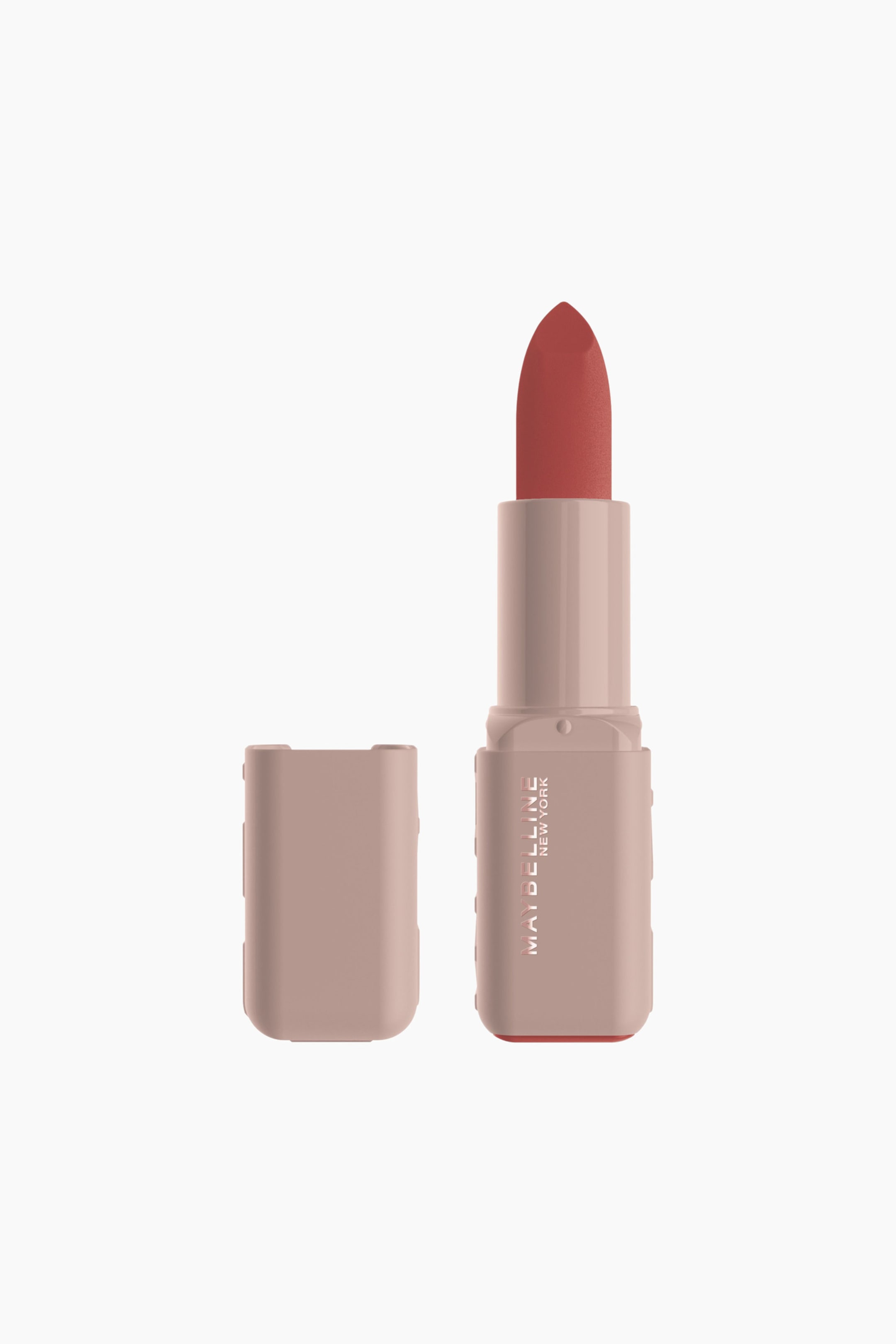 Visa större bild: Ett rödbrunt läppstift står upprätt och visar sin spetsiga läppstiftspets samt ett ljust rosa-beige rektangulärt hölje. Höljet visar varumärket "MAYBELLINE NEW YORK" tryckt vertikalt på ena sidan, och dess botten har en matchande rödbrun färg, medan ett matchande ljust rosa-beige lock ligger bredvid läppstiftet.
