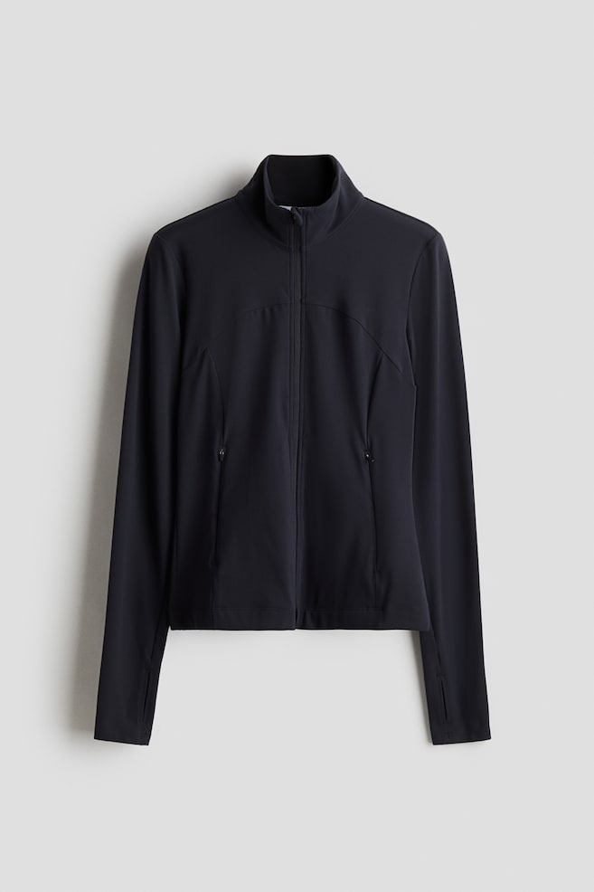 A dark-colored Zip-through sports jacket with SoftMove? is presenting FRONT, featuring a stand-up collar, a full-length front zipper, and two zippered side pockets. Contoured seaming is shaping the front panels, and thumbholes are visible on the extended cuffs. - 1