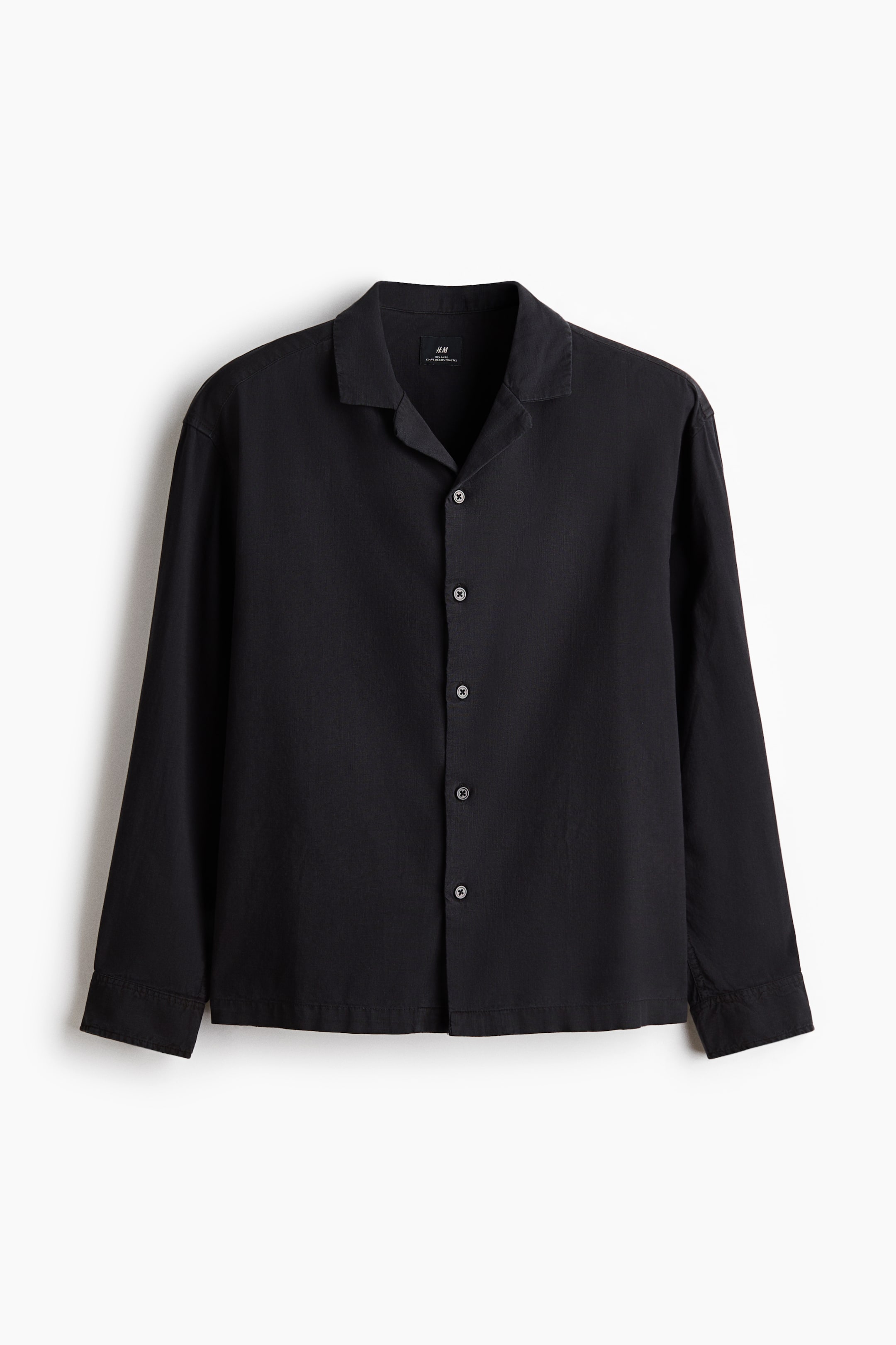 View larger image: A black long-sleeved shirt is shown from the front, featuring an open Cuban collar and a full button-front closure with six dark, four-hole buttons. The shirt has a relaxed fit with straight, unbuttoned cuffs.