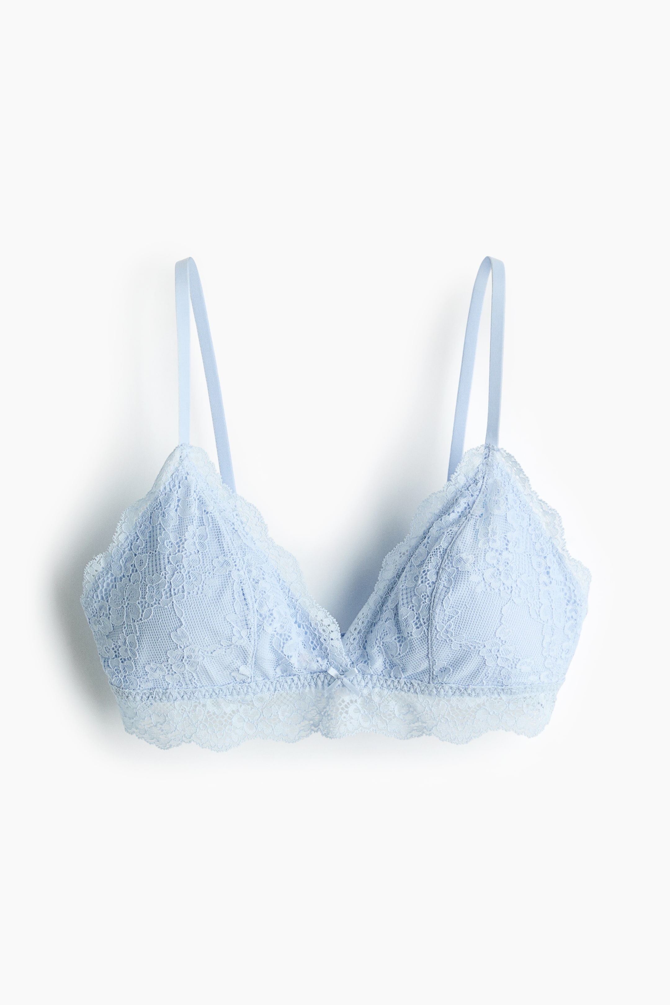 Ampliar la imagen: Un bralette de encaje azul claro se muestra en vista frontal, con copas triangulares con un motivo floral en el encaje y bordes festoneados. Está diseñado con tirantes delgados y una banda de encaje festoneada a juego en la parte inferior, acentuada por un pequeño lazo en el centro.