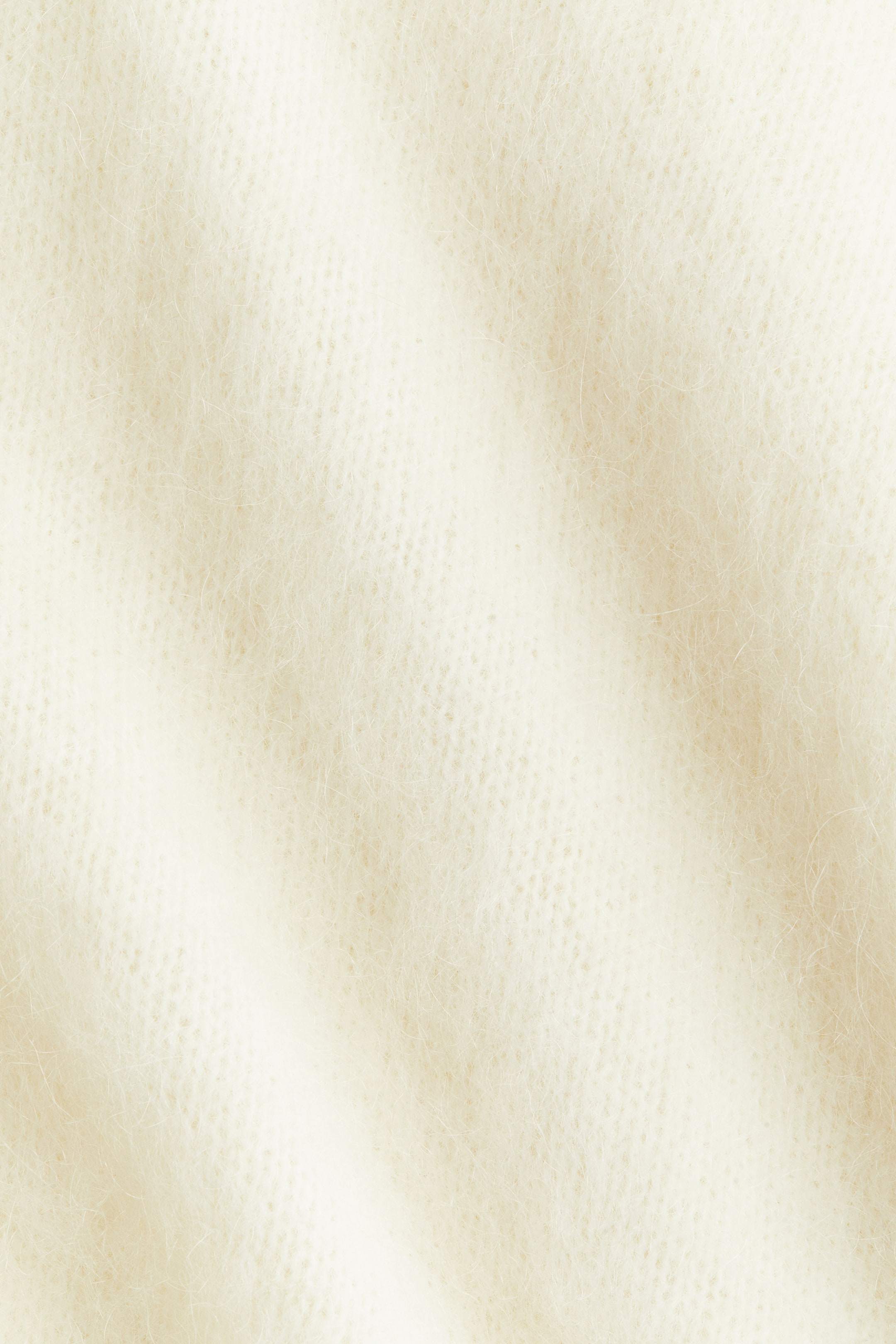 Grösseres Bild ansehen: Ein übergroßer Pullover zeichnet sich durch eine weiche Strickstruktur aus, mit sichtbaren Mohair- und Wollfasern. Er ist mit einem tiefen V-Ausschnitt, tief angesetzten Schultern, langen Ärmeln und schmalen Rippbündchen am Ausschnitt, an den Ärmelbündchen und am Saum gestaltet.