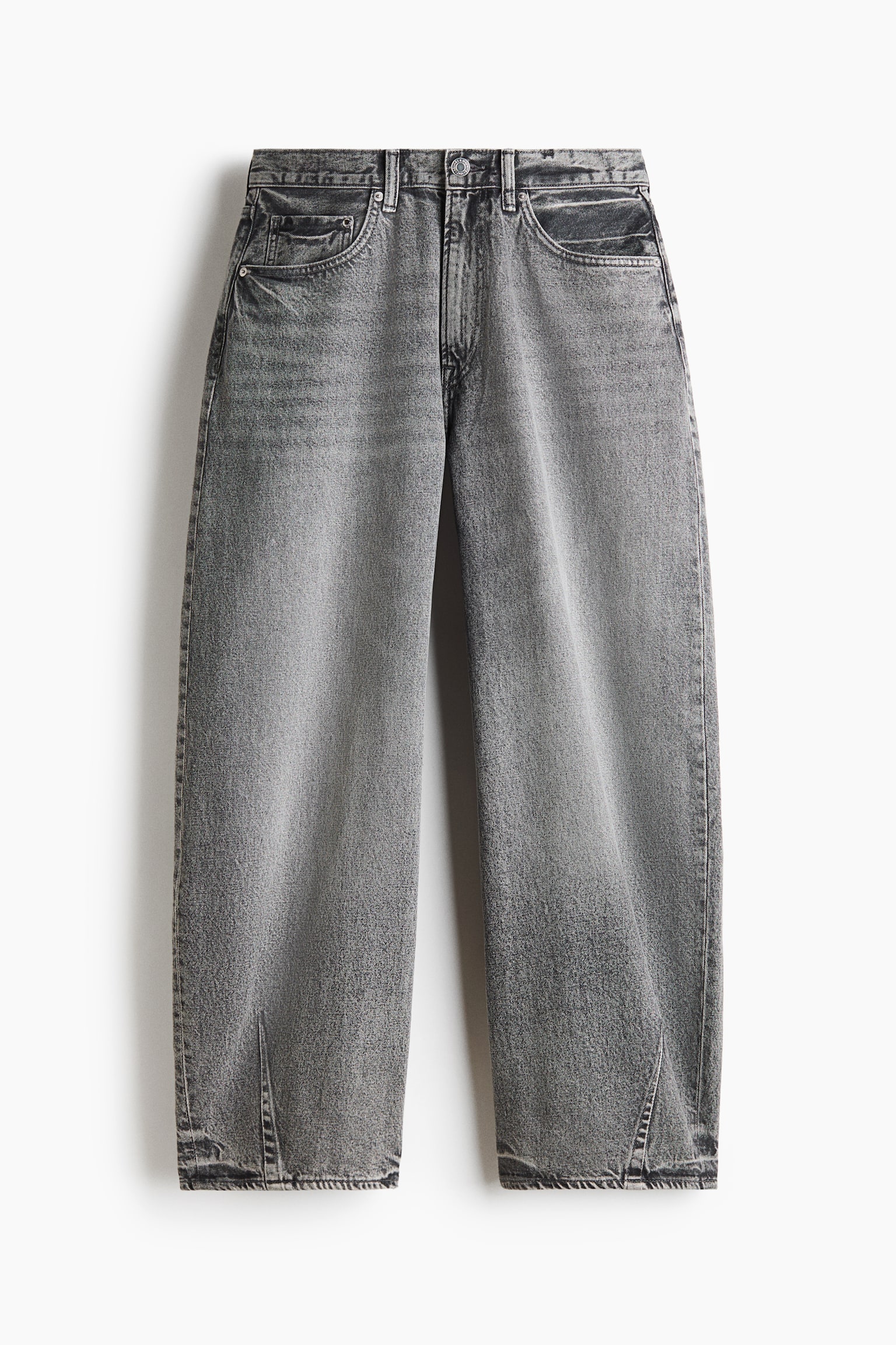 A pair of grey-washed cotton denim jeans is hanging flat, showcasing a regular waist with a zip fly and button closure. The jeans feature a baggy, barrel-leg silhouette with curved legs tapering slightly at the hems.