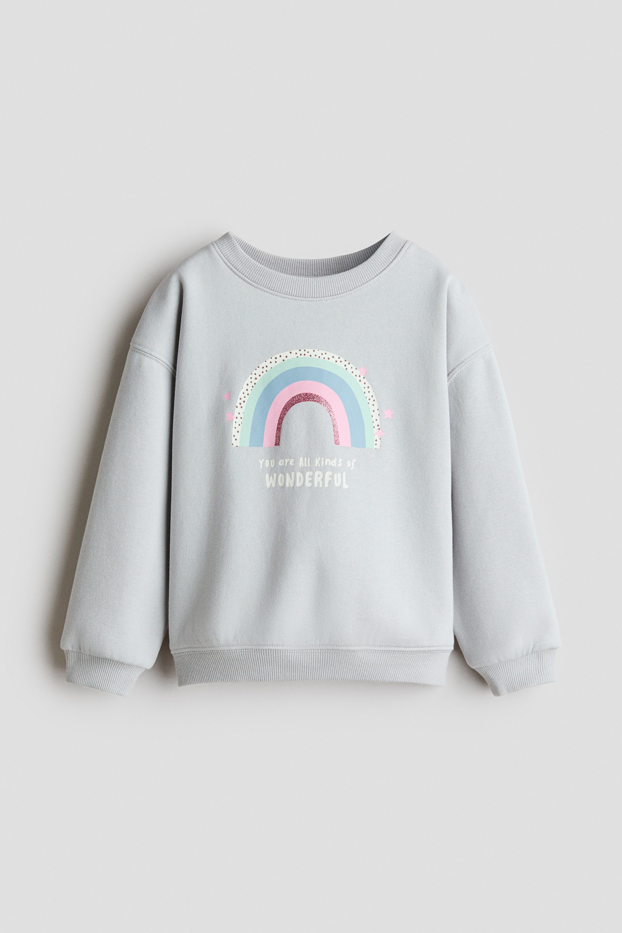 View larger image: A light grey sweatshirt is shown from the front, featuring a pastel rainbow graphic and the text "You are All kinds of WONDERFUL" printed on the chest. It is constructed with a ribbed crew neck, dropped shoulders, and ribbed cuffs and hem.