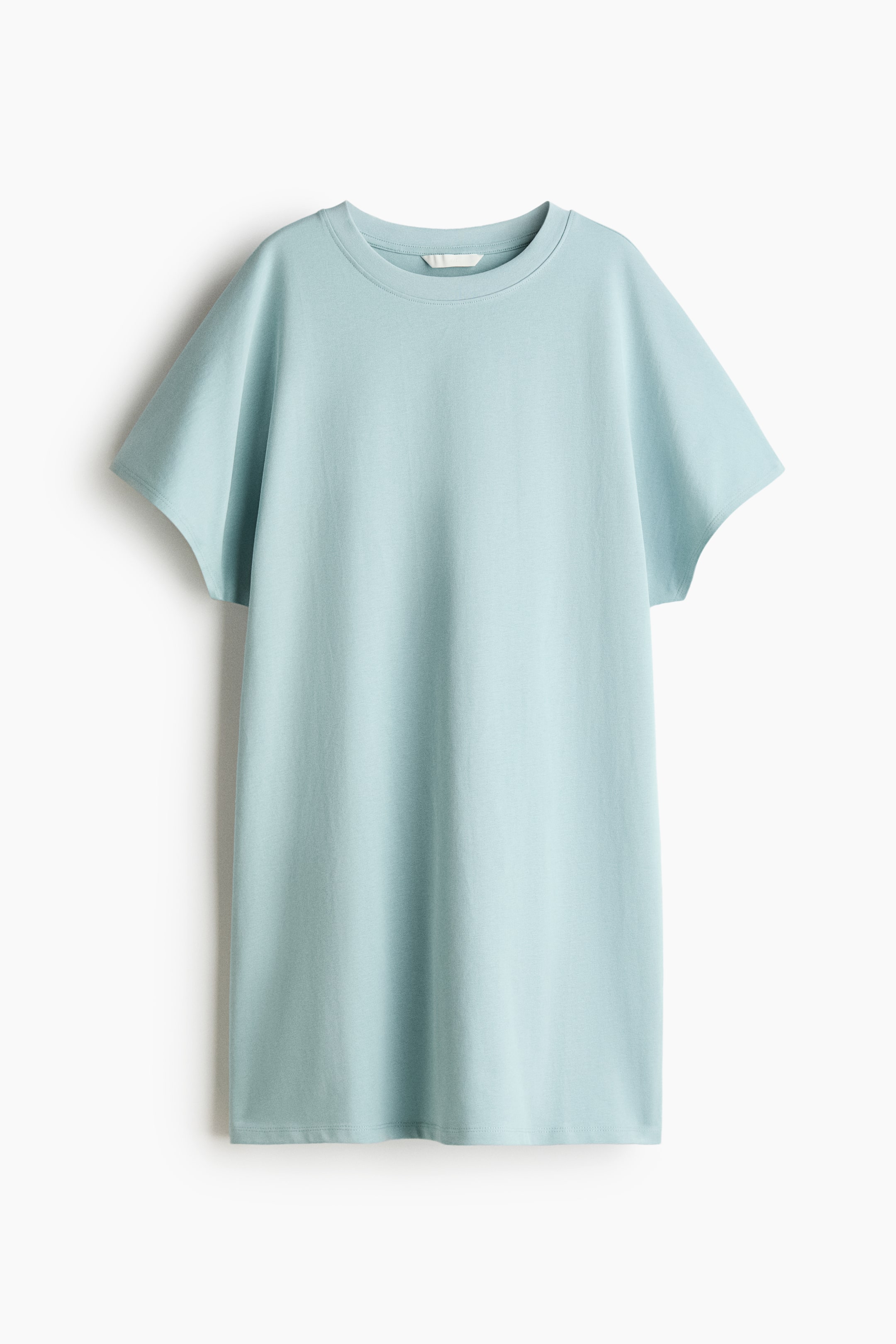 Visa större bild: En ljusblå t-shirtklänning presenteras framifrån, med en rund ribbad halsringning, korta vida ärmar och en avslappnad, rak siluett med rak fåll.