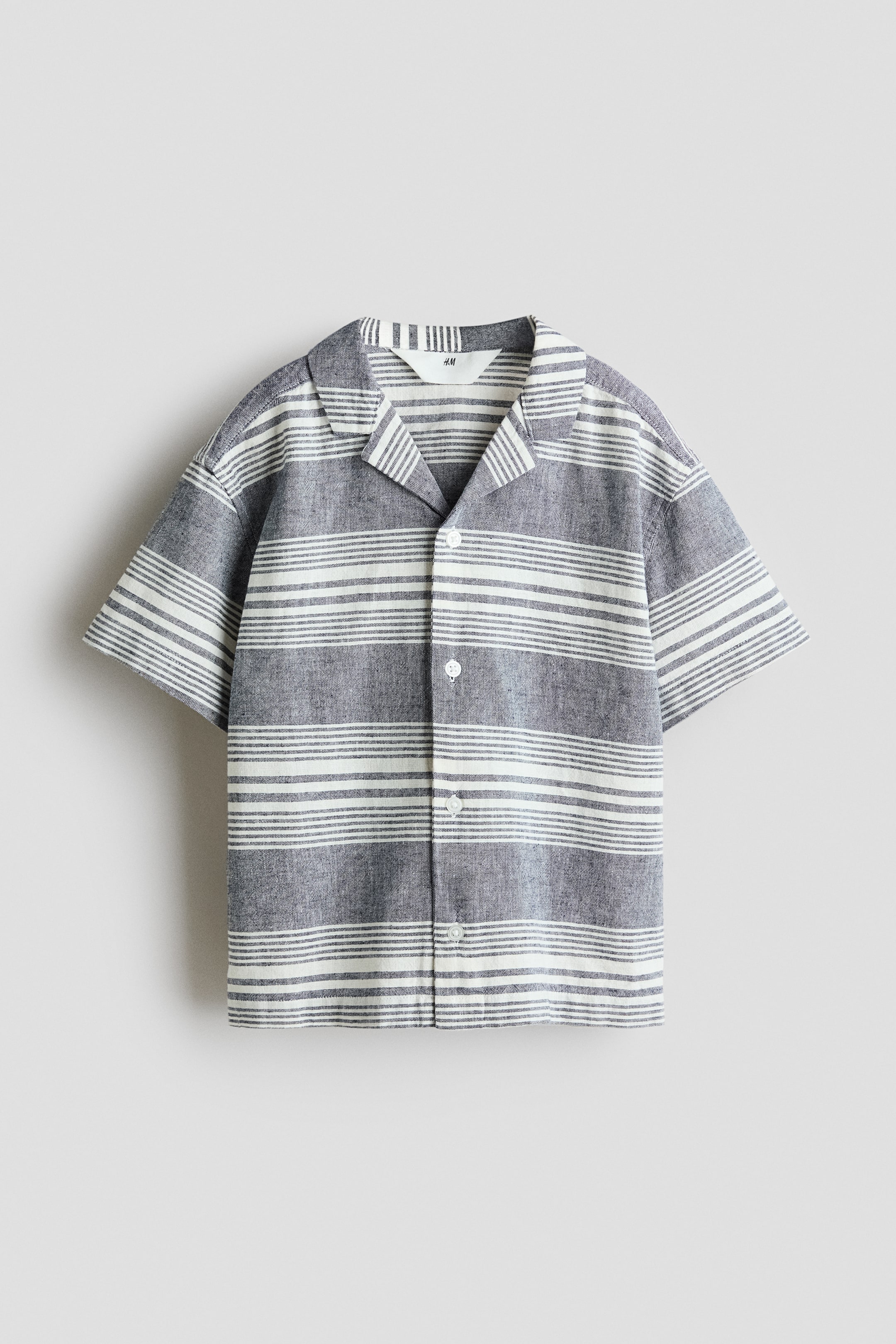 View larger image: A short-sleeved shirt is presented from the FRONT, featuring a gray and off-white horizontal stripe pattern, a revere collar, and a button-front closure with white buttons.
