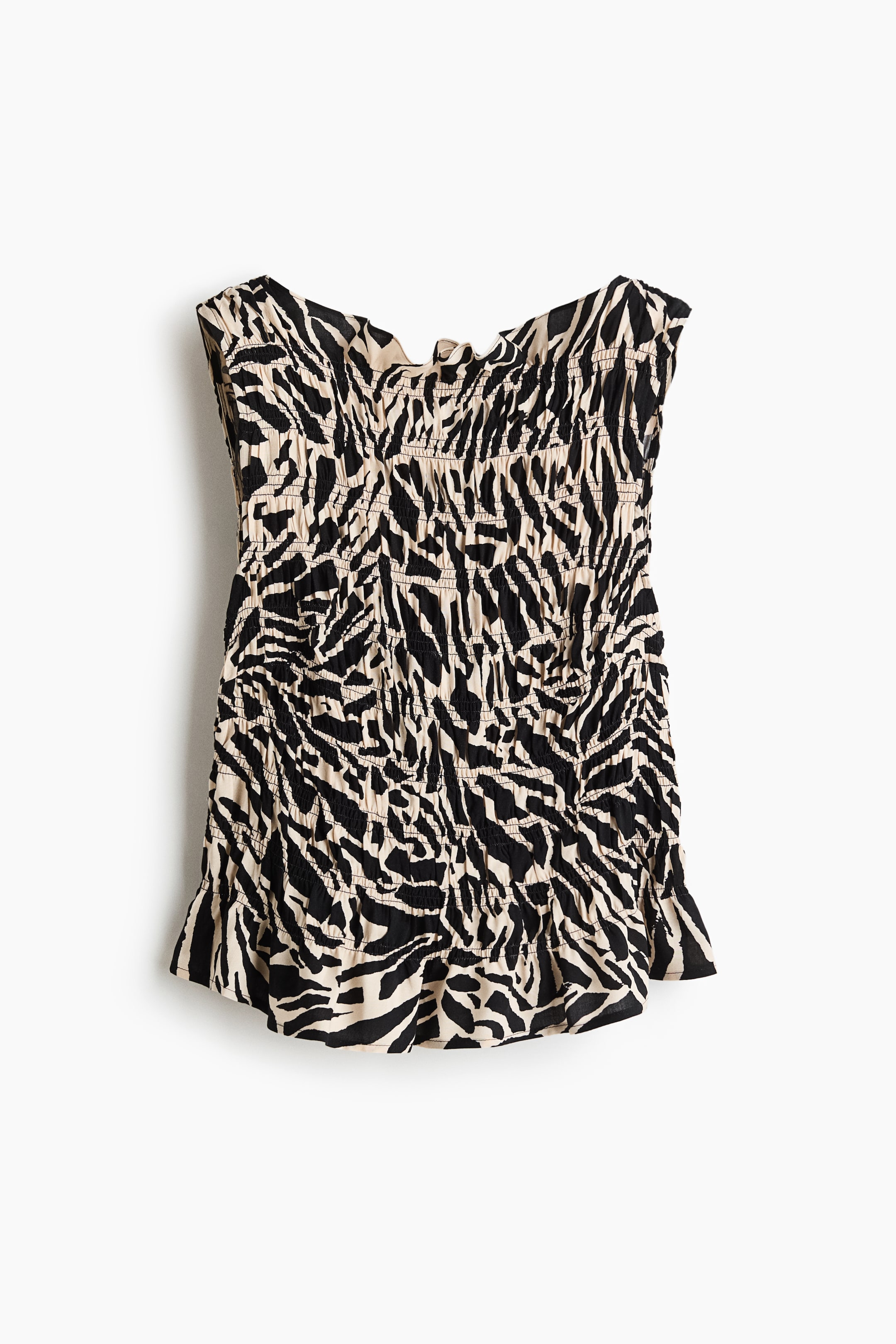 View larger image: A bandeau top is presenting a black and off-white zebra print, featuring an all-over smocked construction that is creating a textured, fitted appearance and is finished with ruffled edges along the top and bottom hems.