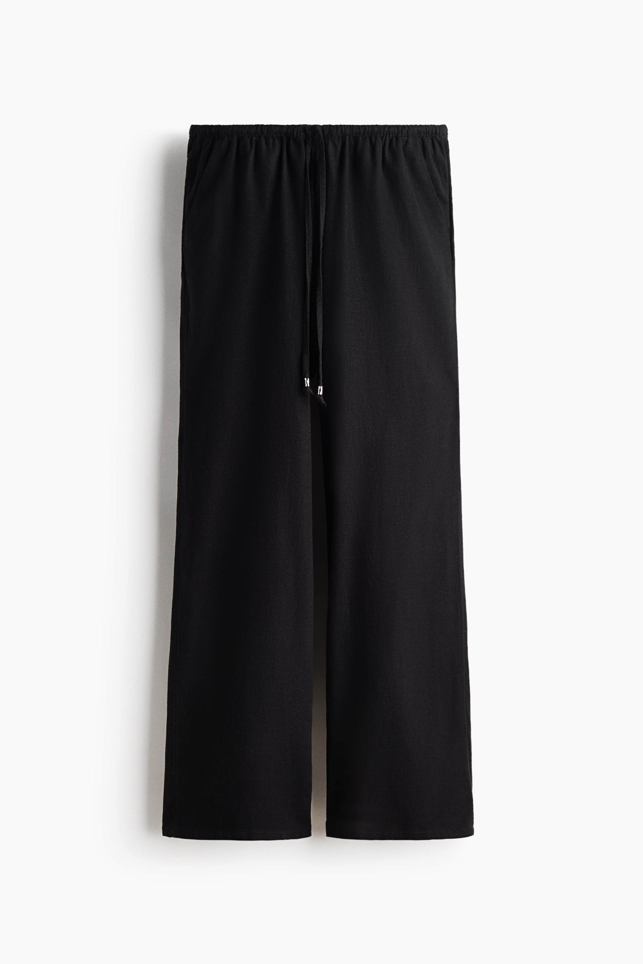 View larger image: Black trousers crafted from a breathable viscose and linen blend are showcased at the FRONT, featuring a low elastic waistband with a drawstring and silver-toned bead accents. They display diagonal side pockets and straight legs.