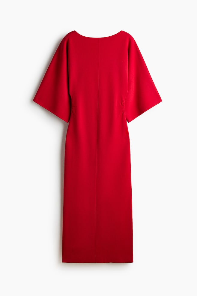 Se muestra de frente un vestido de punto entallado de color rojo, de largo hasta media pantorrilla, con un delicado escote barco y mangas murciélago anchas y cortas. El vestido presenta una costura vertical prominente que recorre el centro del delantero y costuras laterales fruncidas que crean un efecto drapeado en la cintura. - 1