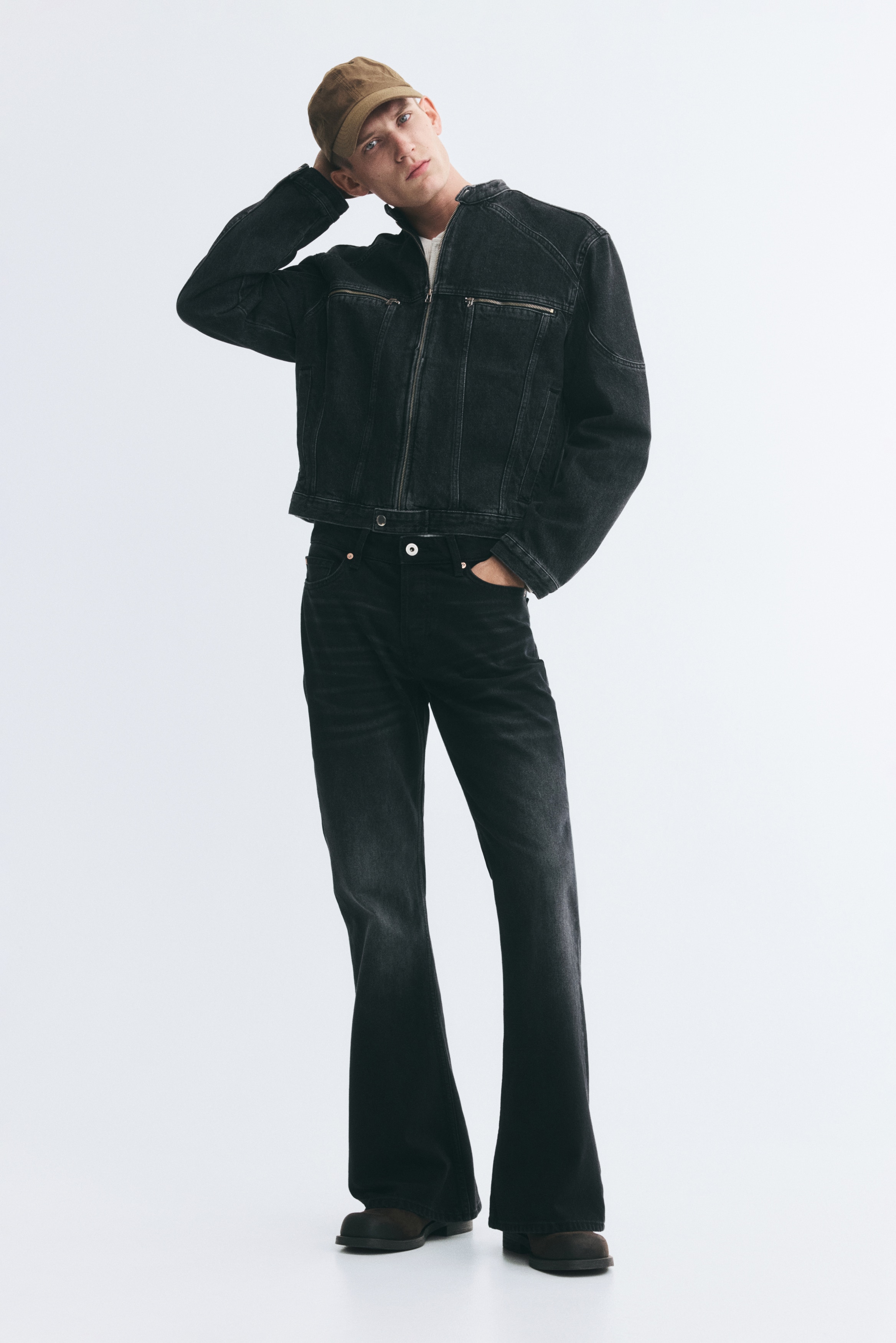 O jachetÄ scurtÄ din denim negru spÄlat este prezentatÄ din faÈÄ, având guler tunicÄ cu capse Èi închidere frontalÄ cu fermoar pe toatÄ lungimea. Designul evidenÈiazÄ cusÄturi de panou proeminente, douÄ buzunare orizontale cu fermoar la piept Èi buzunare laterale verticale tip welo.