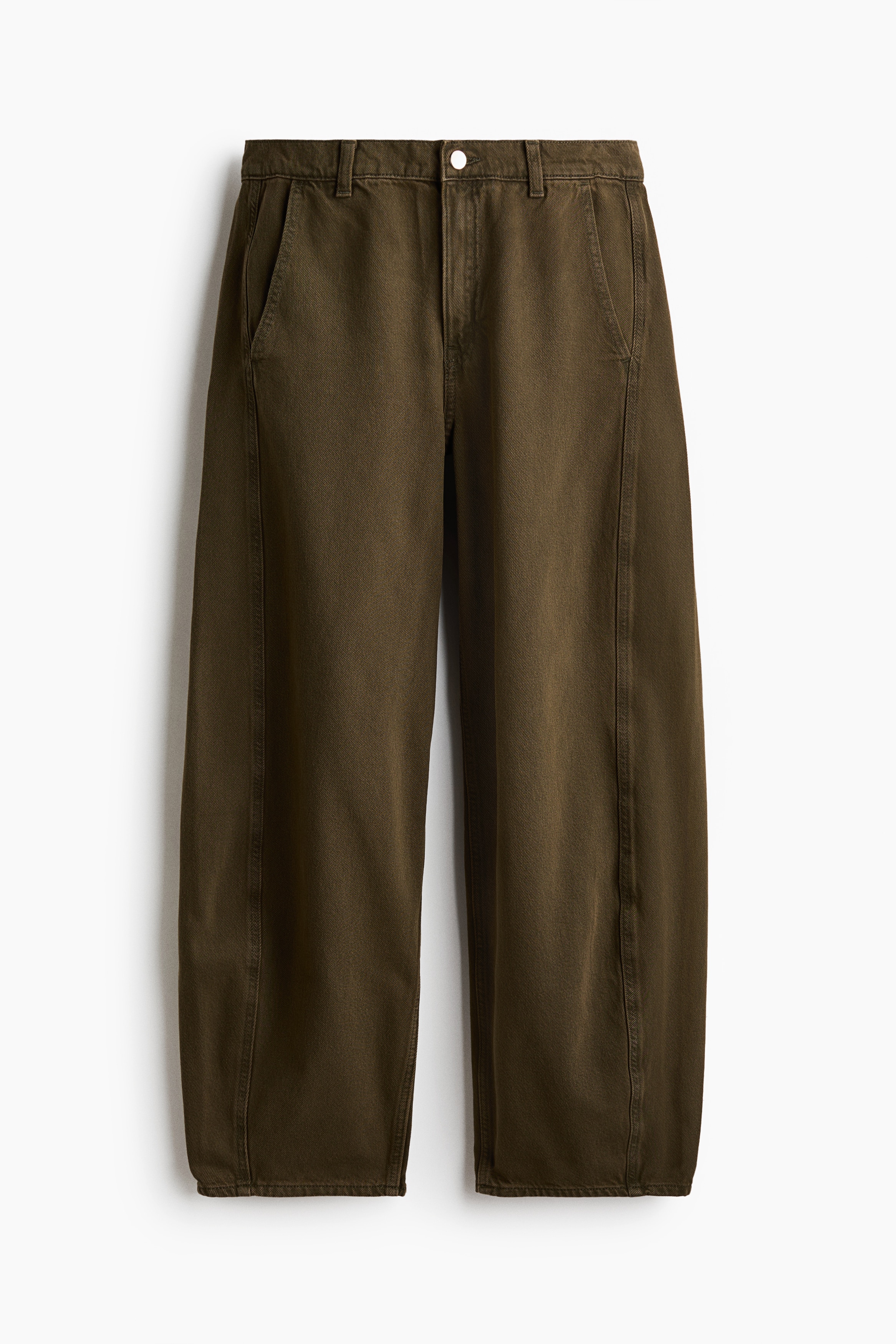 The model is wearing olive green jeans featuring a relaxed, curved-leg silhouette and a regular waist. The tapered jeans are styled with a tucked-in white tank top and a mustard-yellow sweatshirt draped over the shoulders.