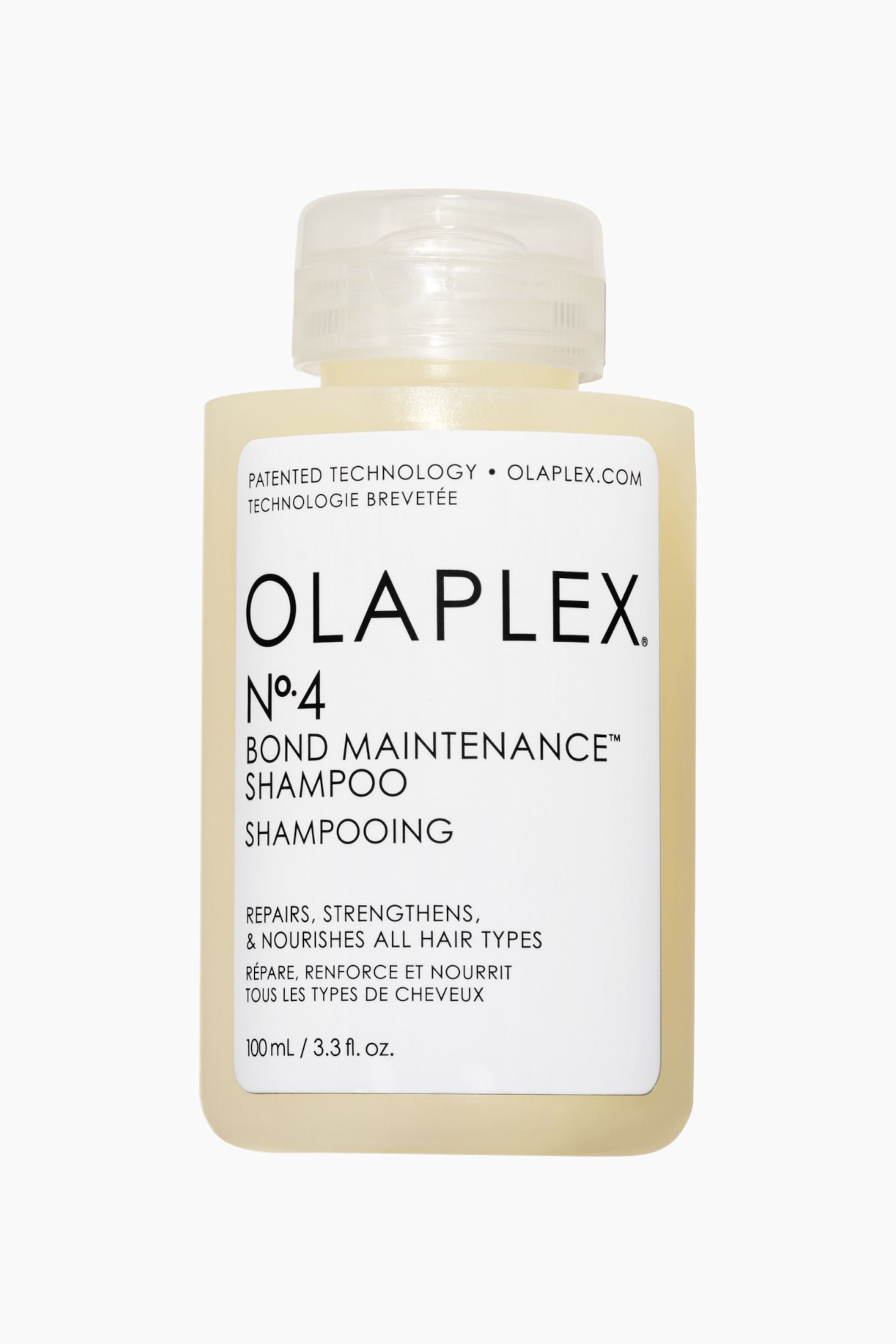 Vis større bilde: En rektangulær Olaplex No. 4 Bond Maintenance Shampoo-flaske står oppreist, med sin frontvendte hvite etikett med produktdetaljer, en klar flip-top kork, og inneholder en gjennomskinnelig, lys gul væske.