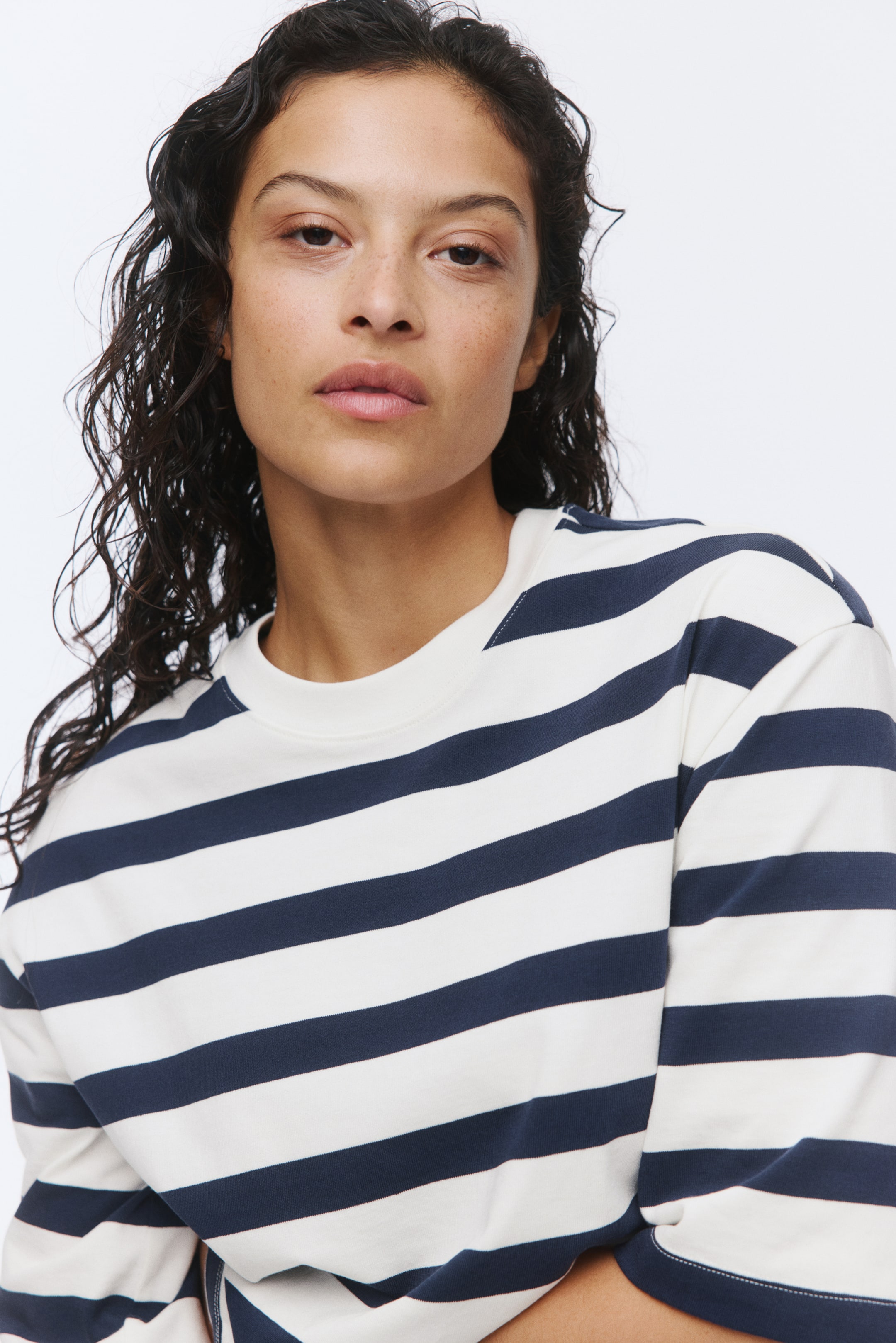 View larger image: The striped sweatshirt boasts cream and navy blue horizontal stripes, complemented by a ribbed cream crew neck. It showcases a relaxed fit, finished with ribbed cuffs on the long sleeves and a ribbed hem.