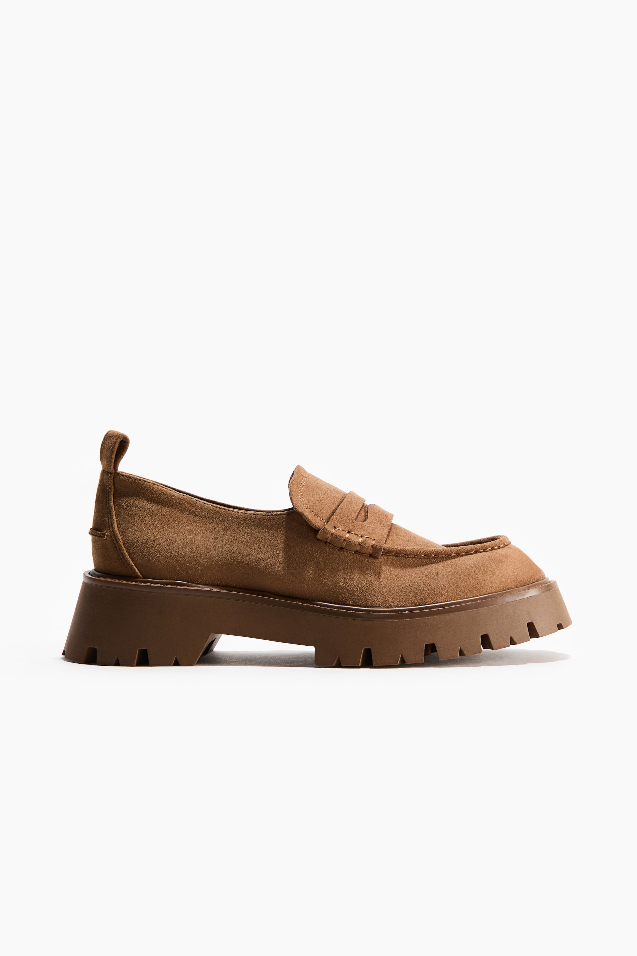 Grösseres Bild ansehen: Ein brauner Wildleder-Loafer zeigt sein Seitenprofil, mit einem Penny-Riemen über dem Spann und sichtbaren Nähten um die Zehenpartie. Er ruht auf einer dicken, dunkelbraunen Profilsohle, mit einer Zugschlaufe, die sich vom Fersenkragen erstreckt.
