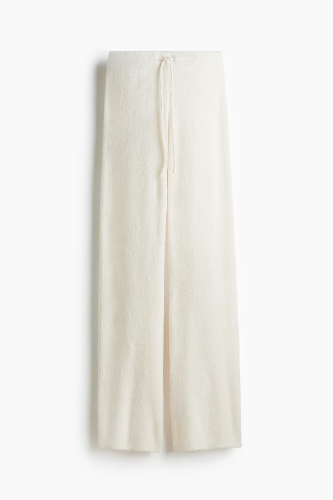 Pantalon ample, blanc cassé, en mélange de laine tricotée douce, exposé de face. Ils présentent une taille élastiquée avec cordon de serrage et des jambes droites. - 1