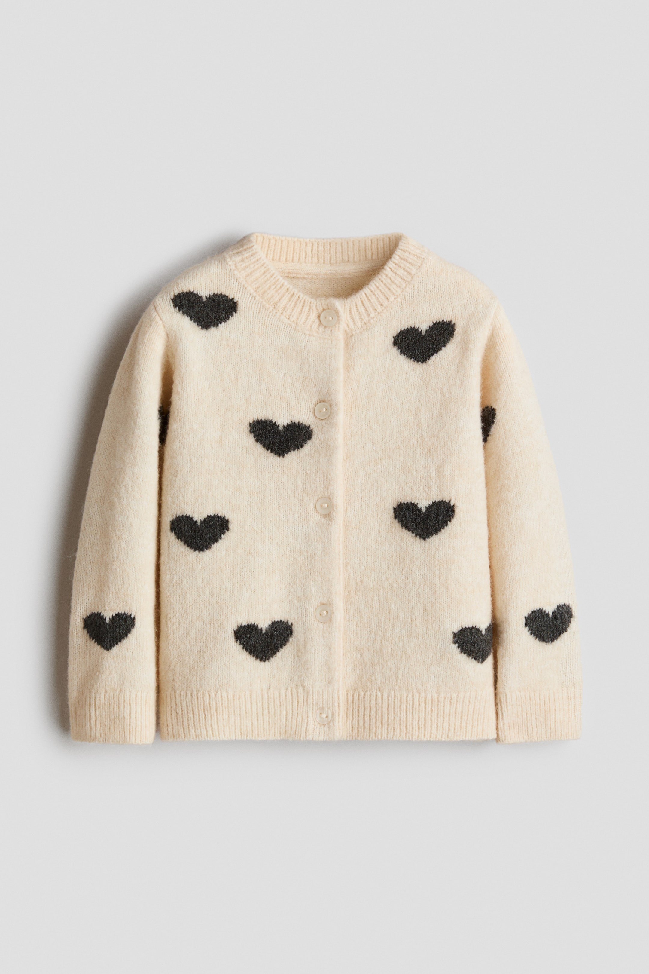 View larger image: A cream-coloured cardigan with black heart patterns is displayed from the front, featuring a soft, fine knit with a slightly brushed finish. It showcases a round, rib-trimmed neckline, buttons down the front, and ribbing at the cuffs and hem.