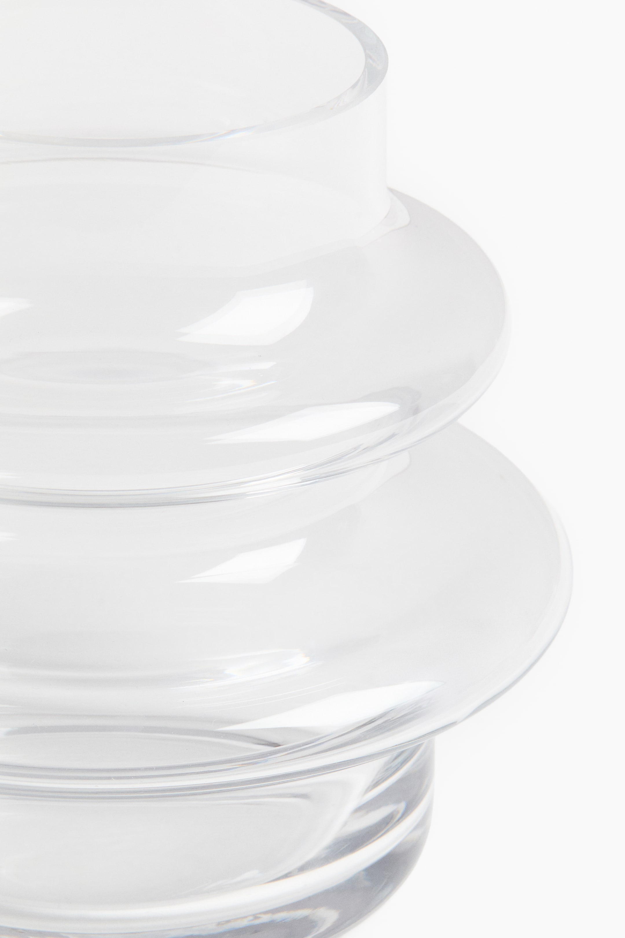 View larger image: A small glass vase features a tiered design, showcasing multiple rounded, clear glass sections stacked visibly.