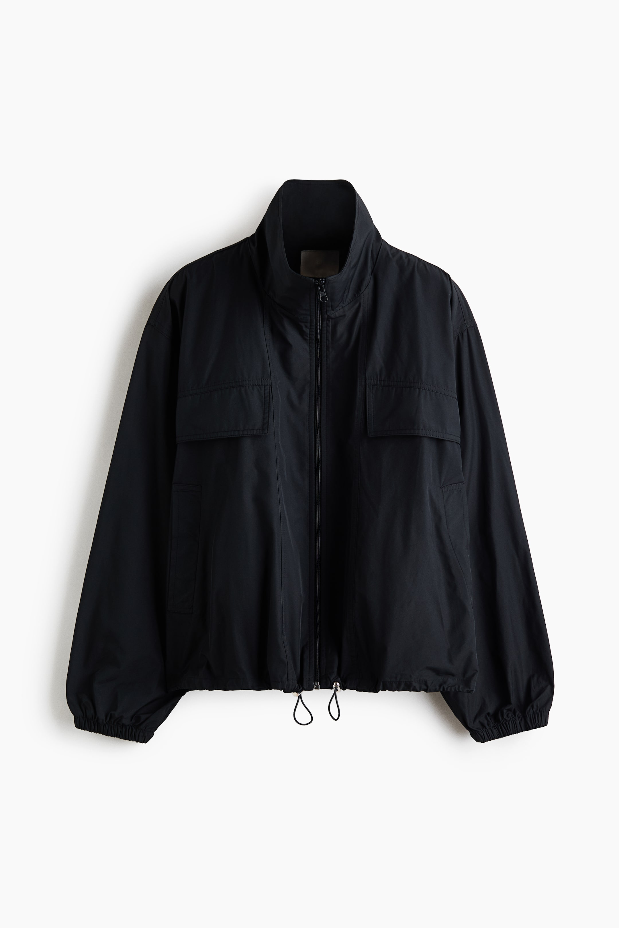 View larger image: A black lightweight jacket is shown from the front, featuring a high stand-up collar, a full-length front zip, and two chest pockets with rectangular flaps. The garment has relaxed-fit long sleeves with elasticated cuffs and an adjustable hem with hanging drawstrings.