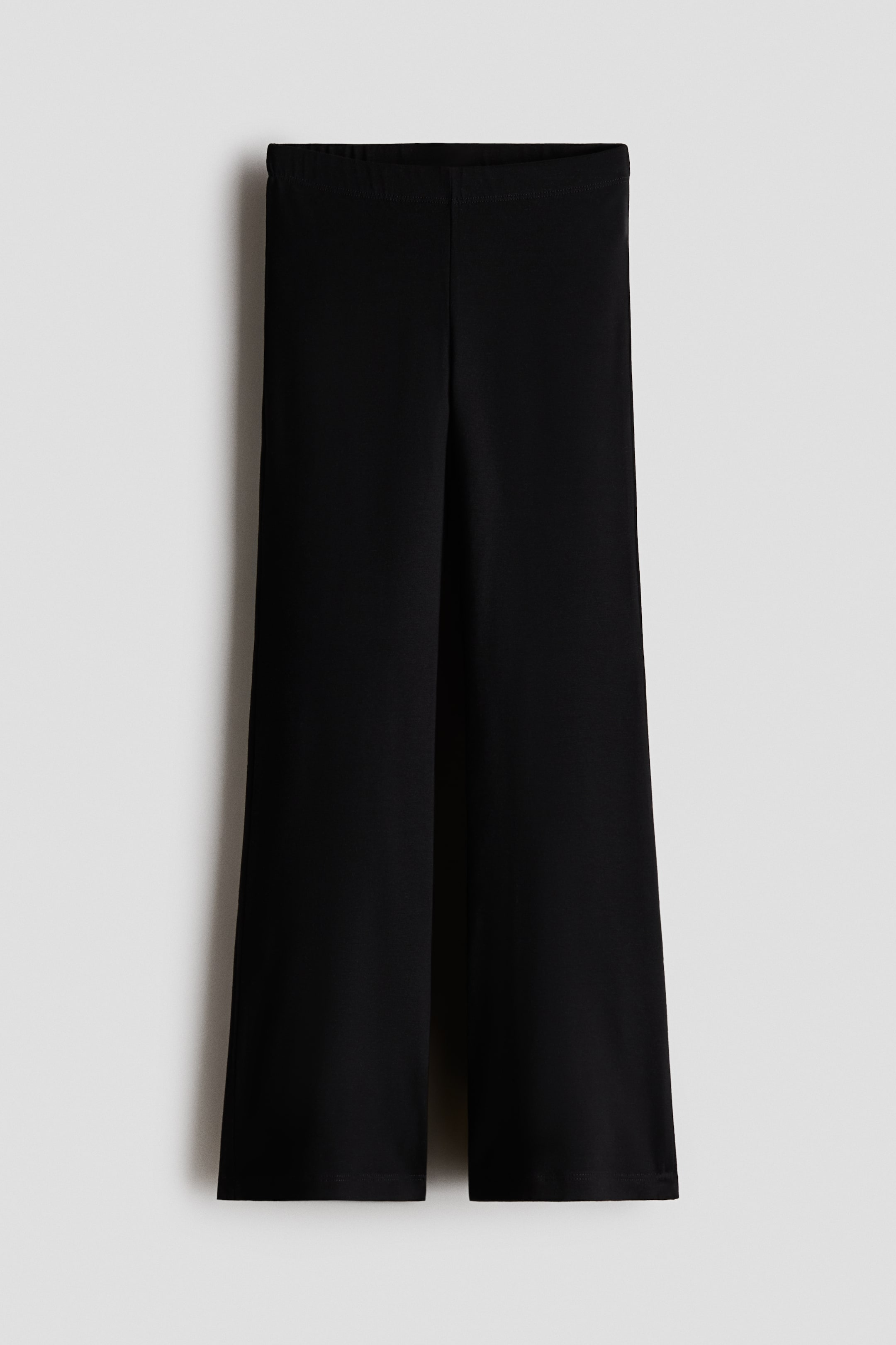 Ampliar la imagen: Leggings de jersey de algodón negro mostrados en vista frontal, con pretina elástica cubierta y basta amplia acampanada.