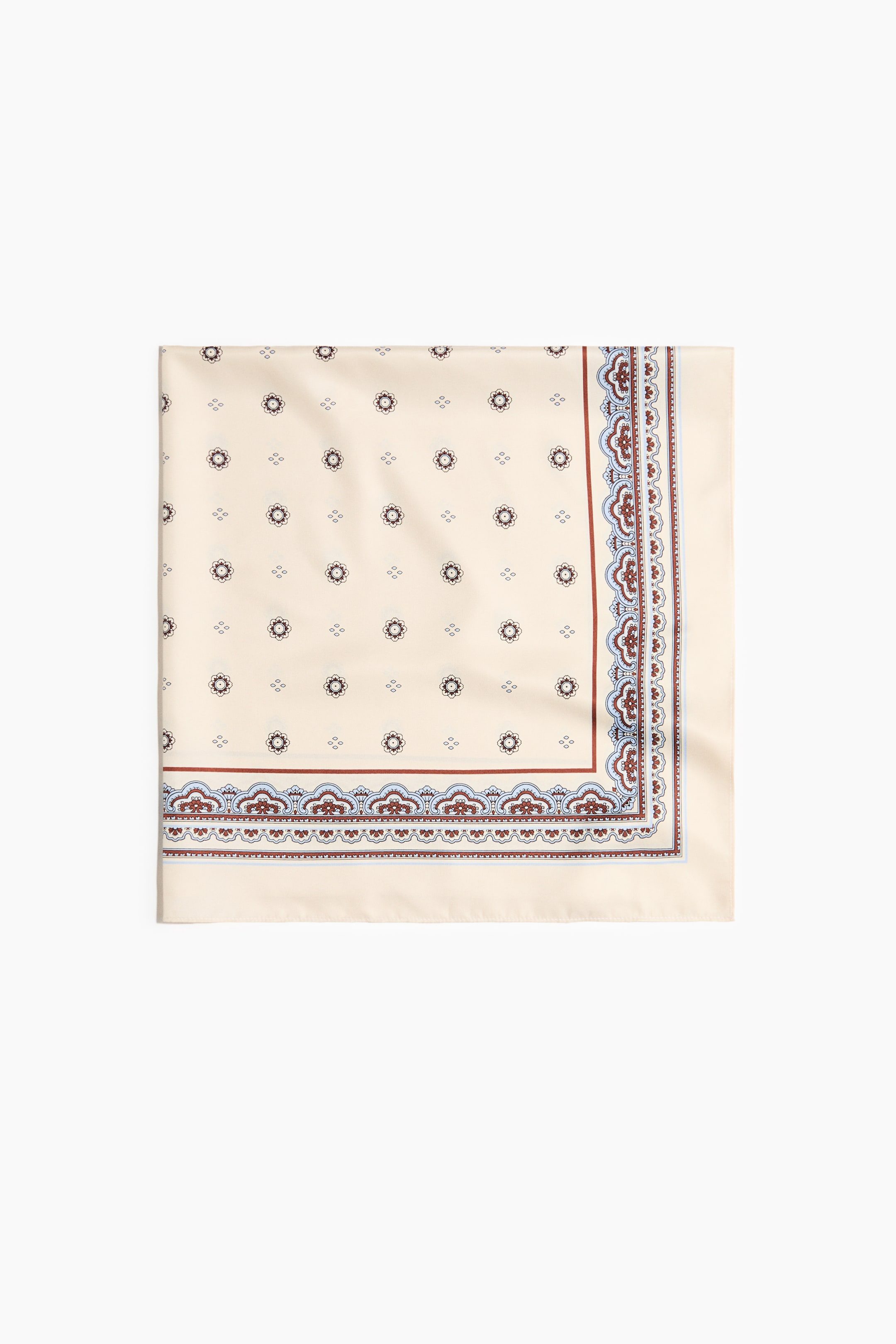 View larger image: A square scarf in a soft weave lies flat, showcasing a cream backdrop adorned with a recurring pattern of petite dark floral motifs. It boasts an intricate border along two sides, embellished with red-brown and light blue designs.