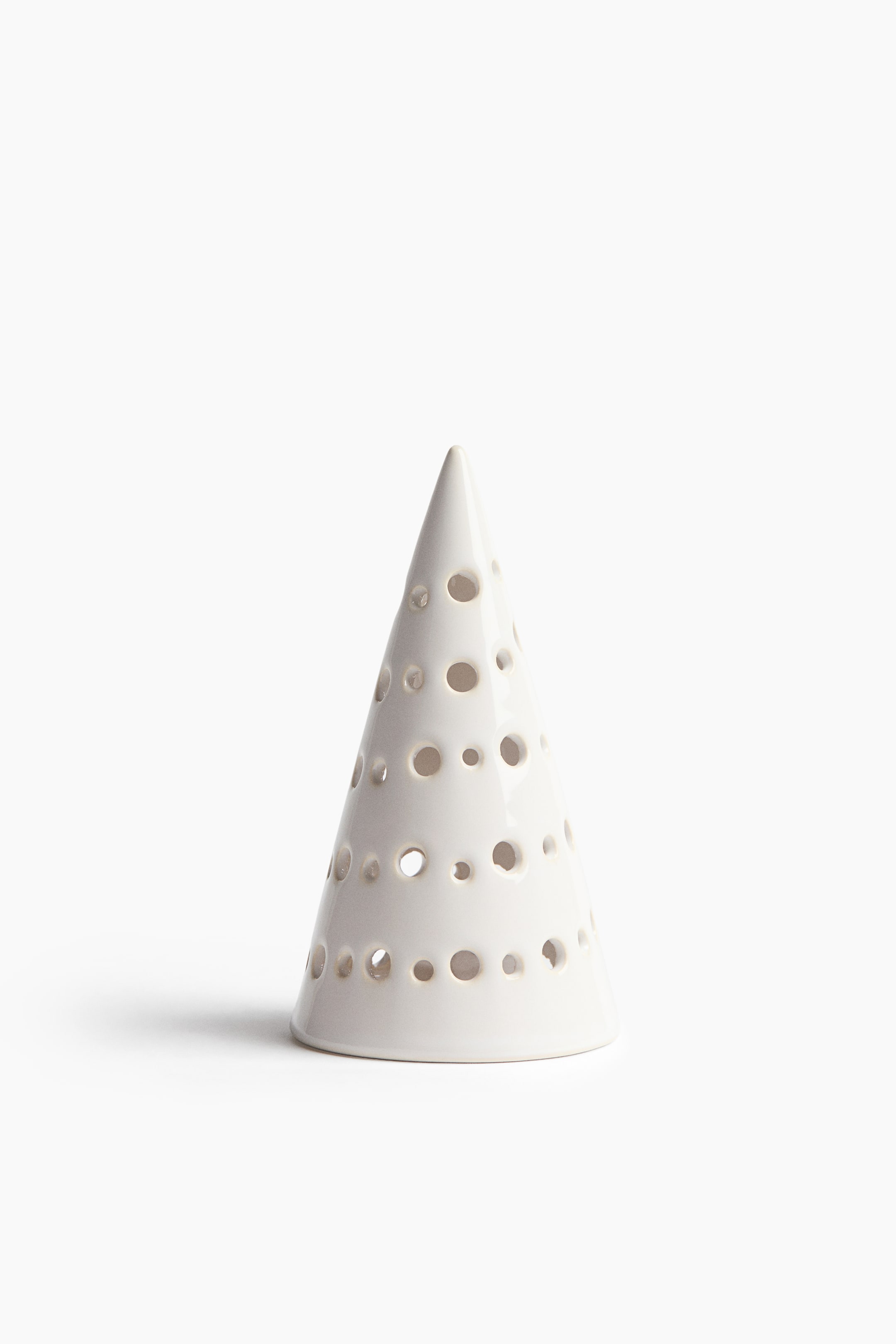 Visualizza immagine più grande: Un cono decorativo in ceramica bianca e lucida è in posizione verticale, caratterizzato da perforazioni circolari di varie dimensioni distribuite sulla sua superficie. Il prodotto si assottiglia fino a una punta dalla base circolare ampia e piatta.