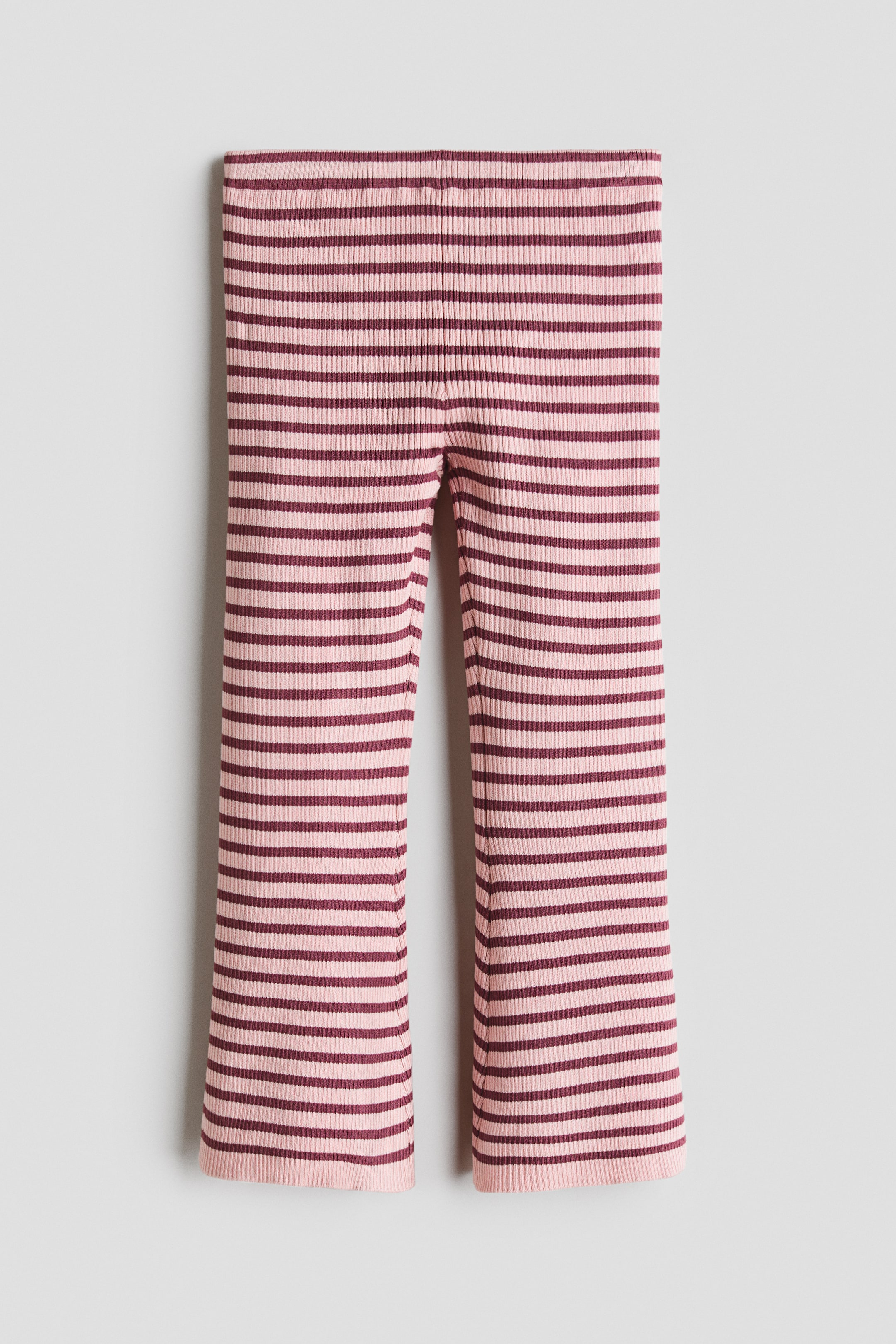 View larger image: The ribbed trousers feature horizontal stripes in light pink and dark red, presenting a slight flare at the ankles from the front.