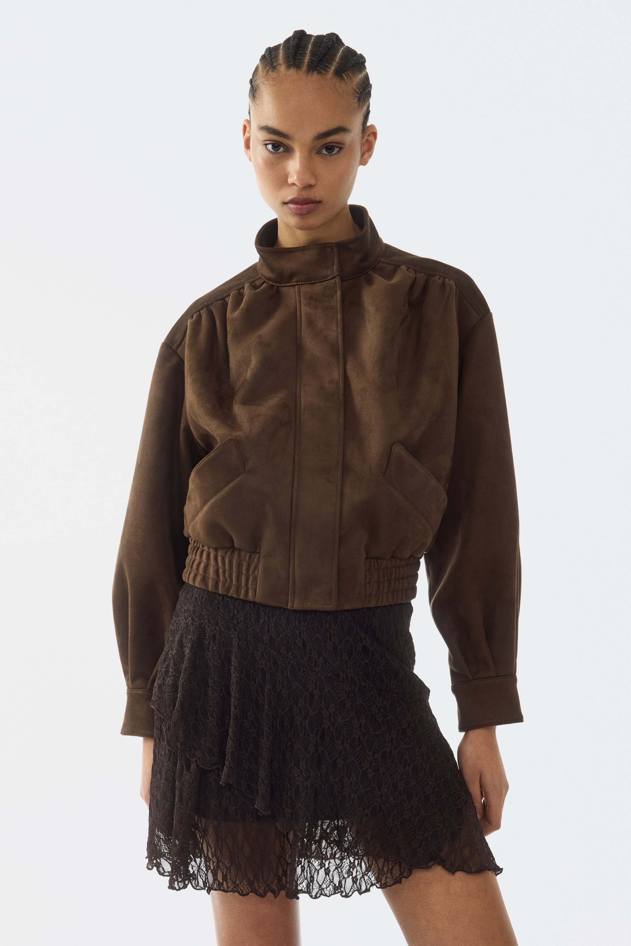 View larger image: "A brown suede-like cropped jacket featuring a high stand collar, gathered shoulders, a ribbed hem, and two angled flap pockets on the front."