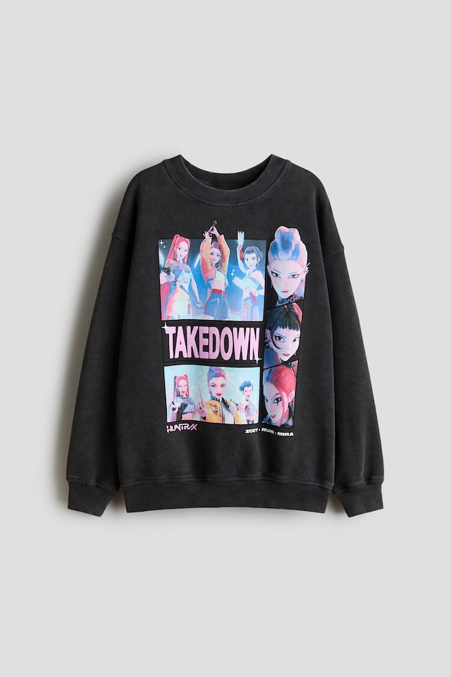 A front view of an oversized, dark grey sweatshirt features a large rectangular graphic print on the front, showcasing multiple animated female characters and text including "TAKEDOWN". It is designed with a round, rib-trimmed neckline, dropped shoulders and ribbed cuffs and hem. - 1