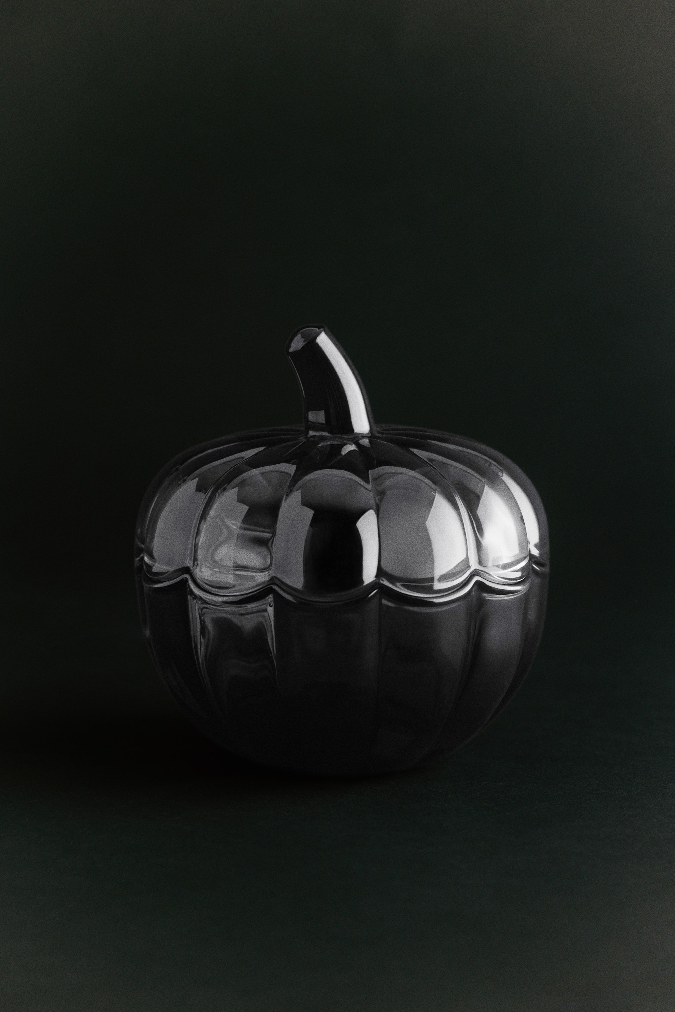 View larger image: A dark glass jar with a matching lid is displaying a ribbed pumpkin design from a front-facing angle. The lid features a curved stem handle on top, with scalloped edges that align with the lobed base of the jar.