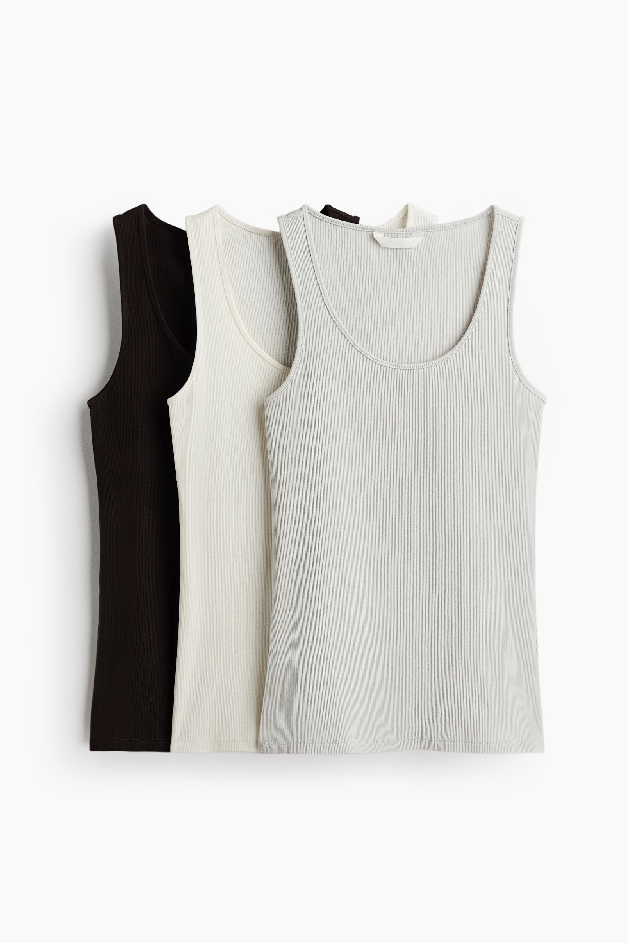 View larger image: "Ribbed jersey fitted tank tops with a scoop neckline come as a set of three in dark brown, off-white, and light gray. The light gray top is layered over the off-white top, which is layered over the dark brown top, with all tops facing forward."