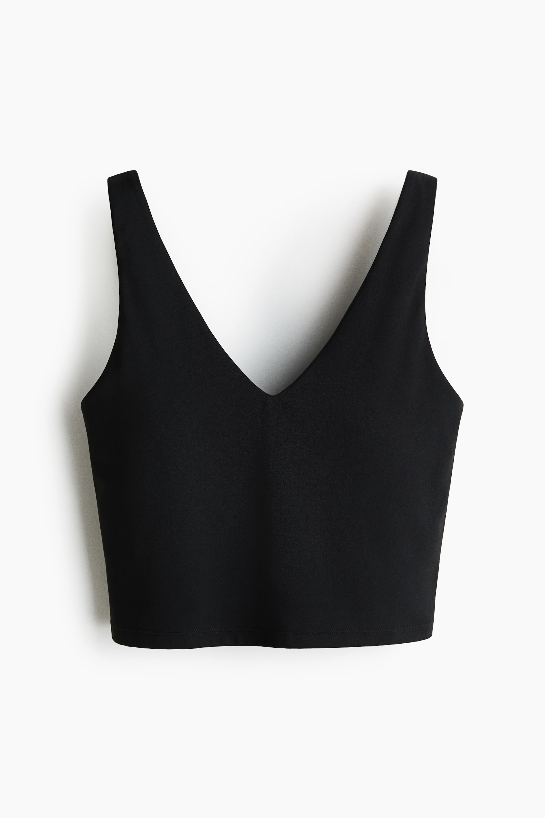 View larger image: A black crop top is displayed from the front, showcasing a deep V-neckline, wide shoulder straps, and a straight bottom hem.
