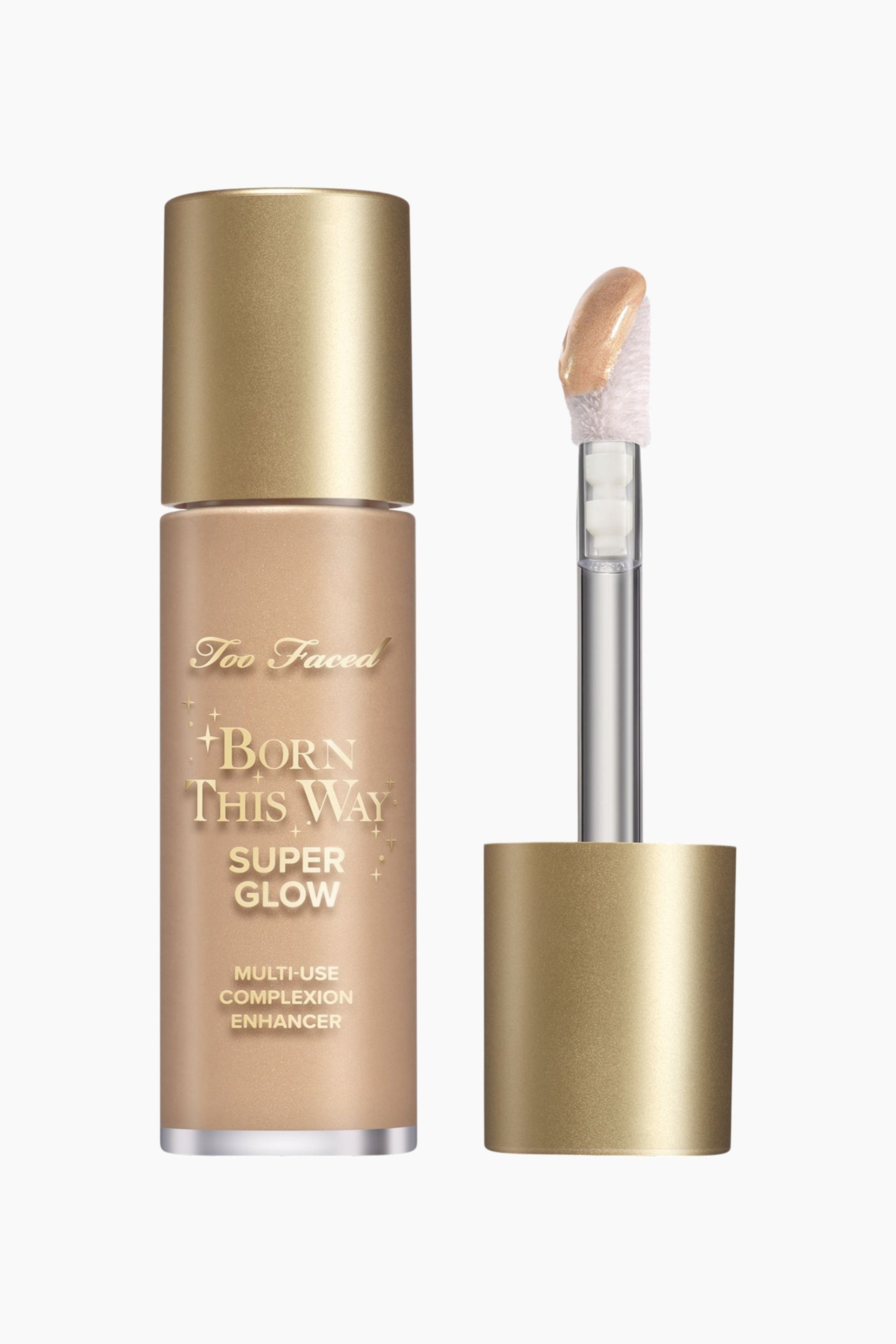 Visa större bild: En flaska av Too Faced Born This Way Super Glow Multi-Use Complexion Enhancer står upprätt, med ett guldfärgat lock och en ljusgul skimrande vätska med produktnamnet tryckt i guldskrift. Bredvid flaskan hålls applikatorstaven av sitt guldfärgade lock, med sin flockade spets täckt av en glittrande ljusgul produkt, vinklad något åt vänster.