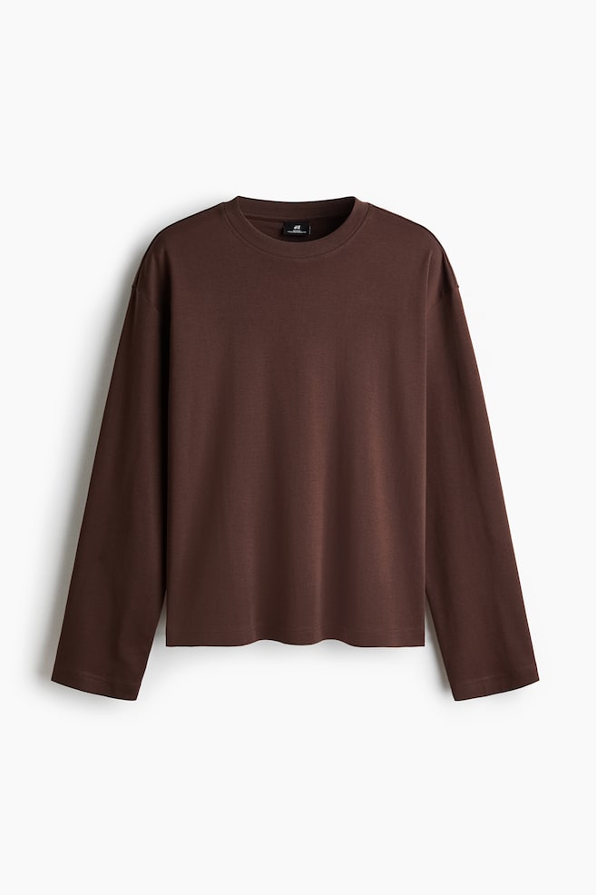 Una camiseta marrón de manga larga está orientada hacia adelante, con cuello redondo, hombros caídos y dobladillo recto. Presenta un corte holgado con mangas largas. - 1