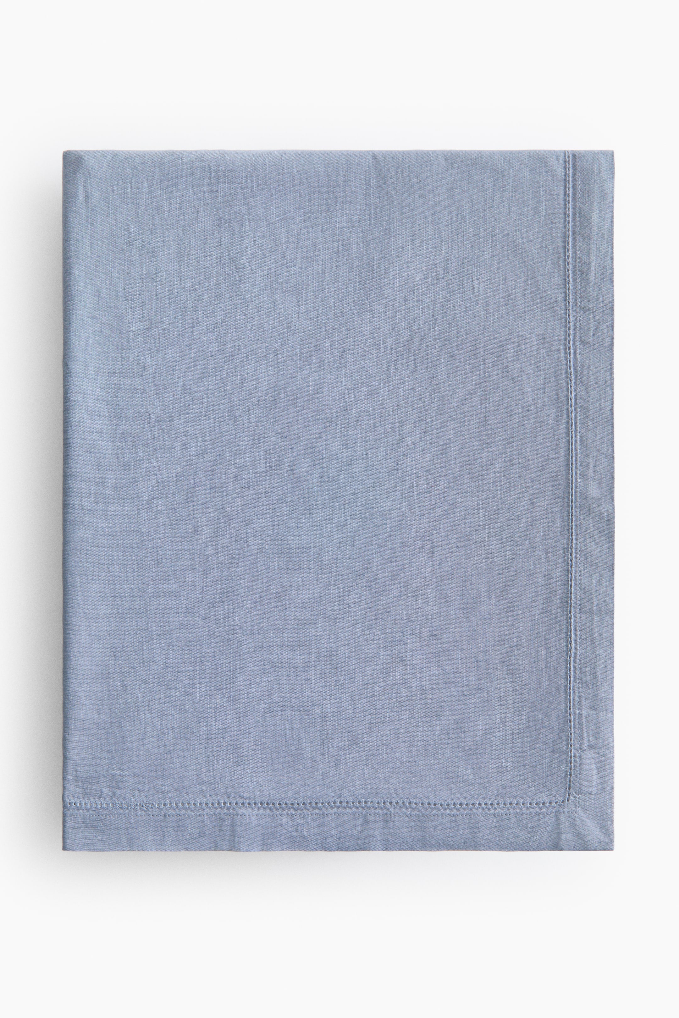 View larger image: The tablecloth is showcased in a square fold, highlighting its dusty blue hue and hemstitch detailing along the edges, creating a noticeable hem.