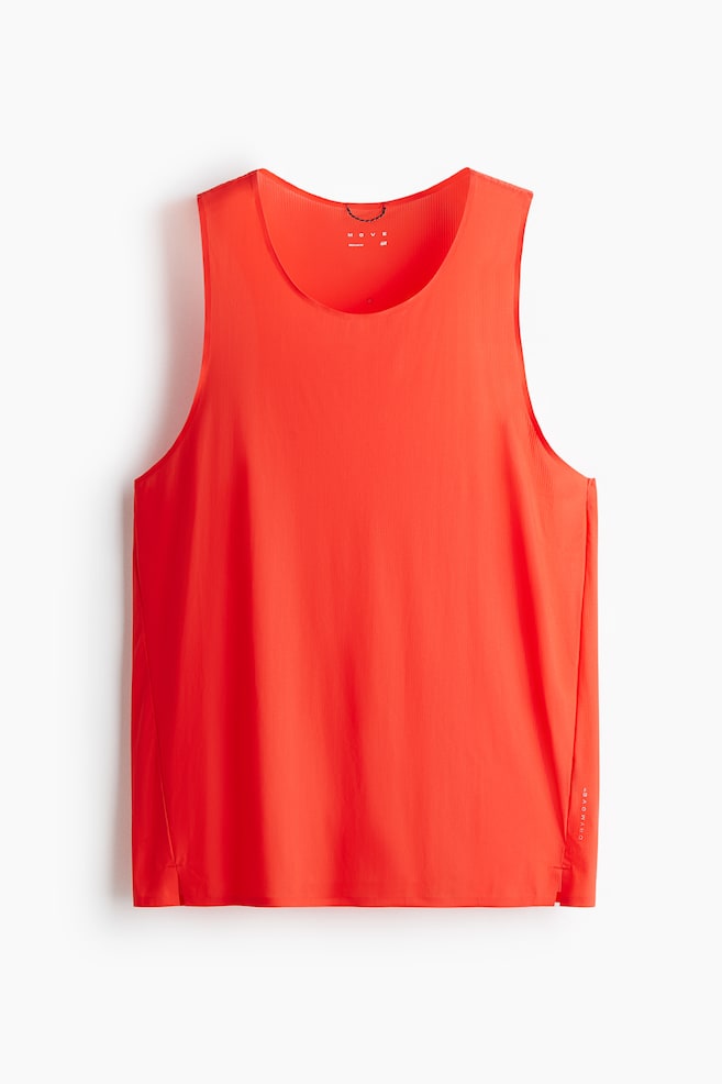 Un débardeur de course ajusté de couleur rouge vif présente un col rond et un fin côtelage vertical sur l'ensemble de son tissu. Il est présenté de face, affichant de petites fentes latérales à l'ourlet et la marque "DRYMOVE" imprimée verticalement sur le côté inférieur droit. - 1