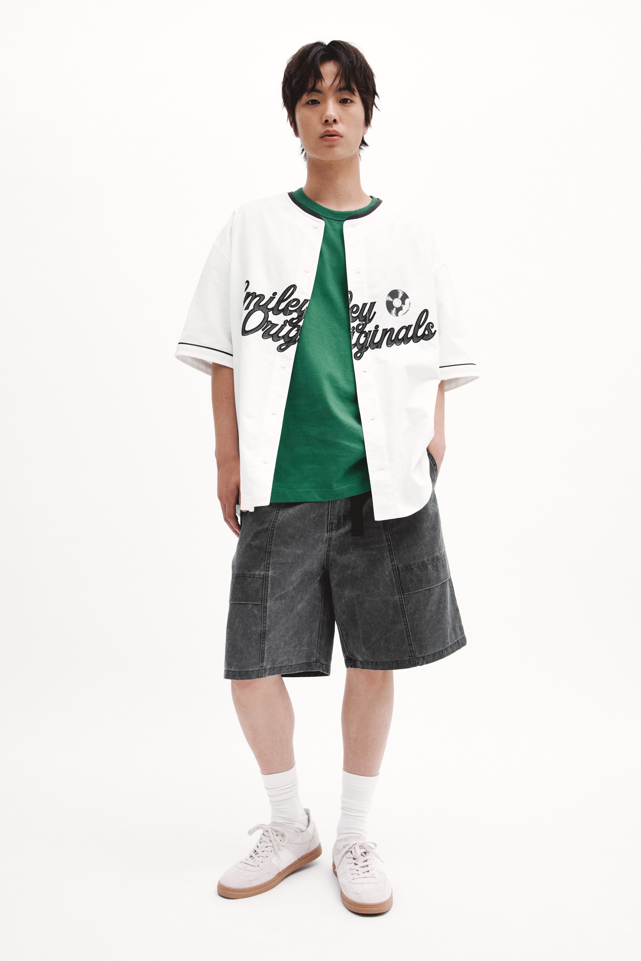 Xem ảnh lớn hơn: Người mẫu đang mặc quần short vải cotton chéo màu tối, đặt một tay vào túi bên chéo. Quần short được thiết kế với dây đai lưới nổi bật, túi bên chéo và túi chân có nắp kín đáo.