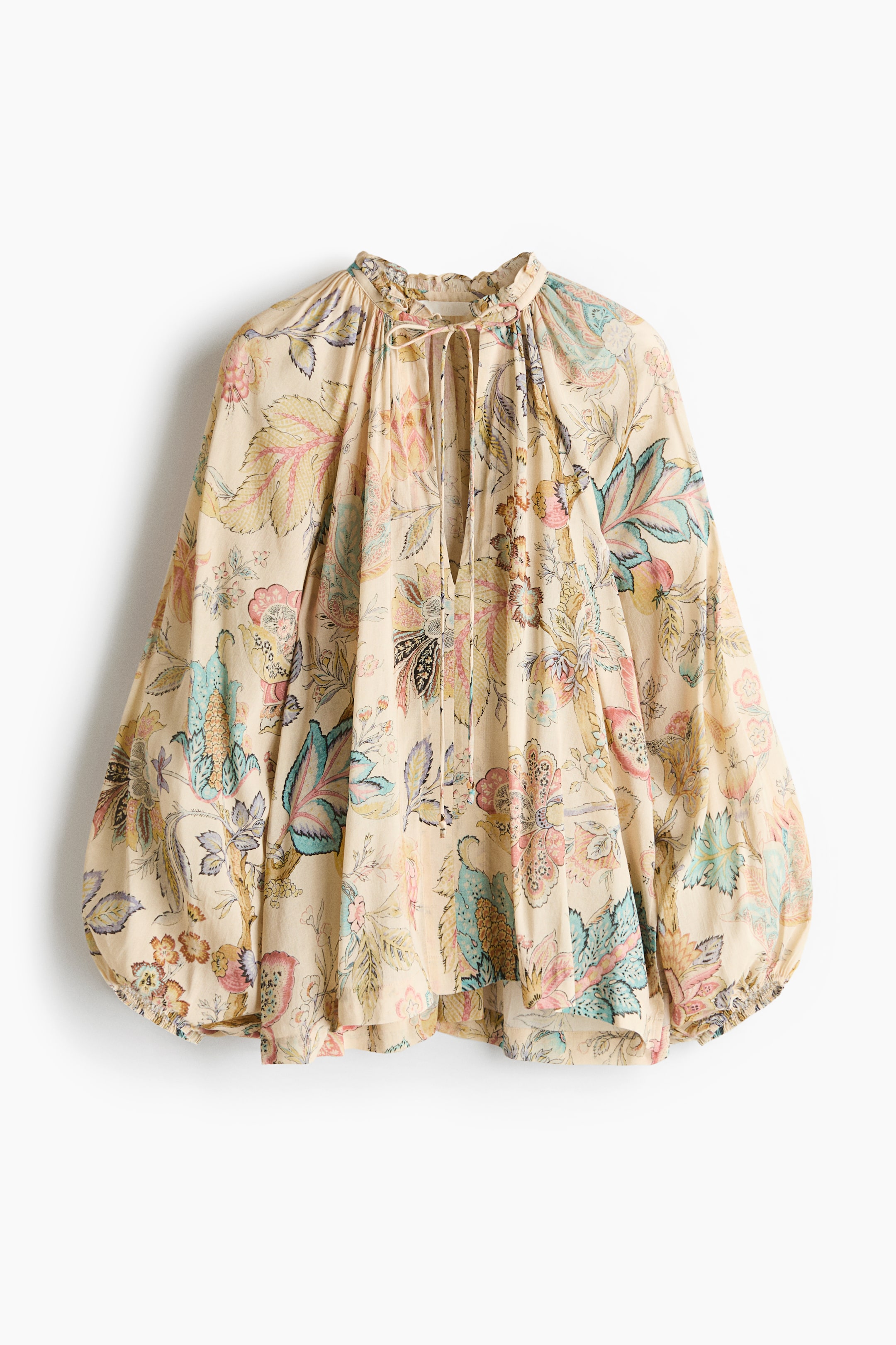 View larger image: An oversized blouse crafted from a cream viscose and cotton blend, adorned with a vibrant floral and leaf pattern, is showcased at the front. It features a round neckline with gathered detailing and a delicate frill trim, a deep V-shaped opening with narrow ties accented by beads, long balloon sleeves with a raglan cut and narrow elasticated cuffs, and slits on each side of the hem.