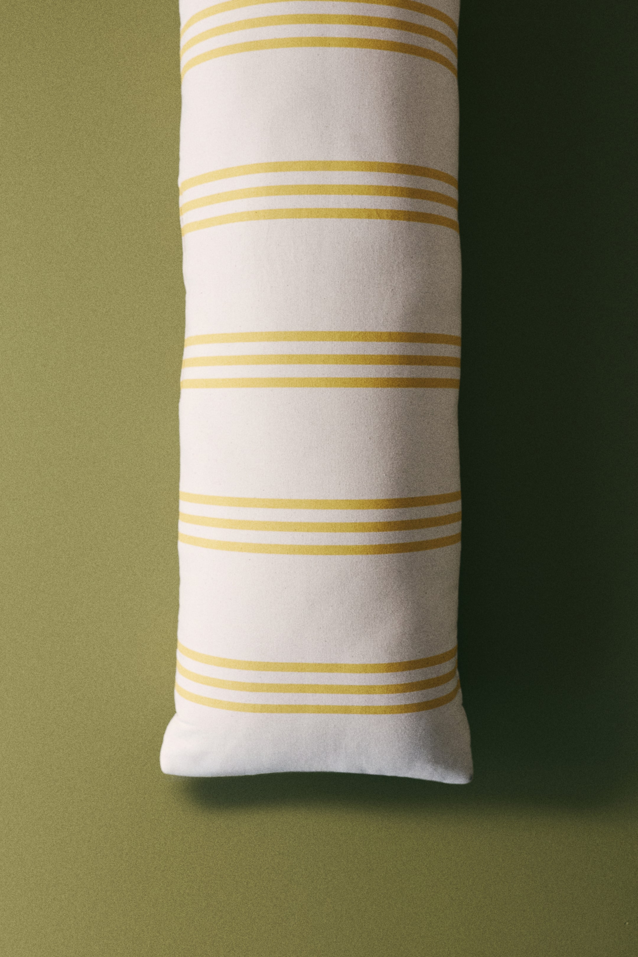 View larger image: A rectangular cushion is displayed facing forward, showcasing a white background with horizontal yellow stripes arranged in groups of three thin lines.