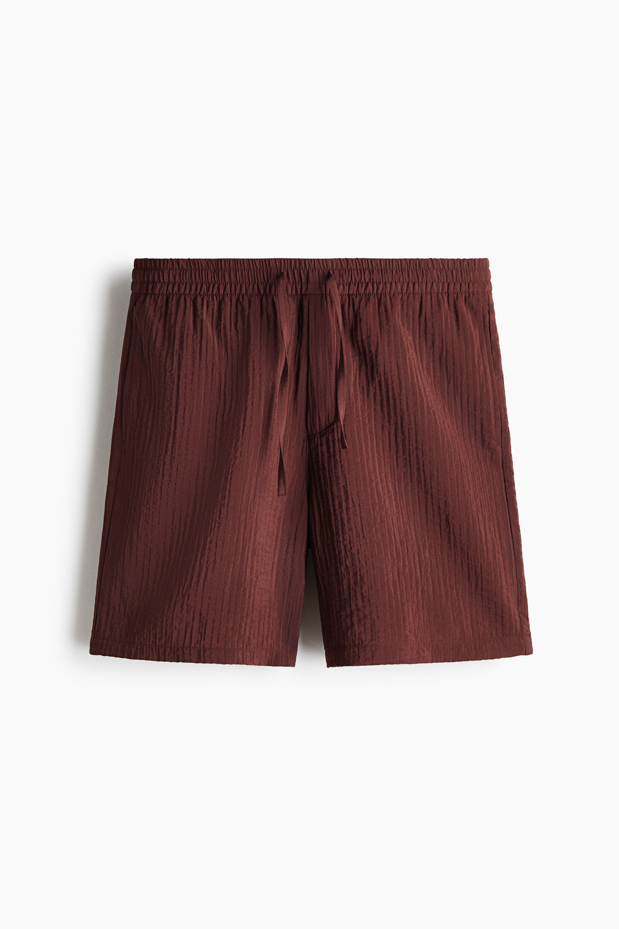 View larger image: Shorts, shown from the FRONT, feature a dark reddish-brown, vertically ridged textured fabric. They are designed with an elastic waistband and a visible front drawstring.