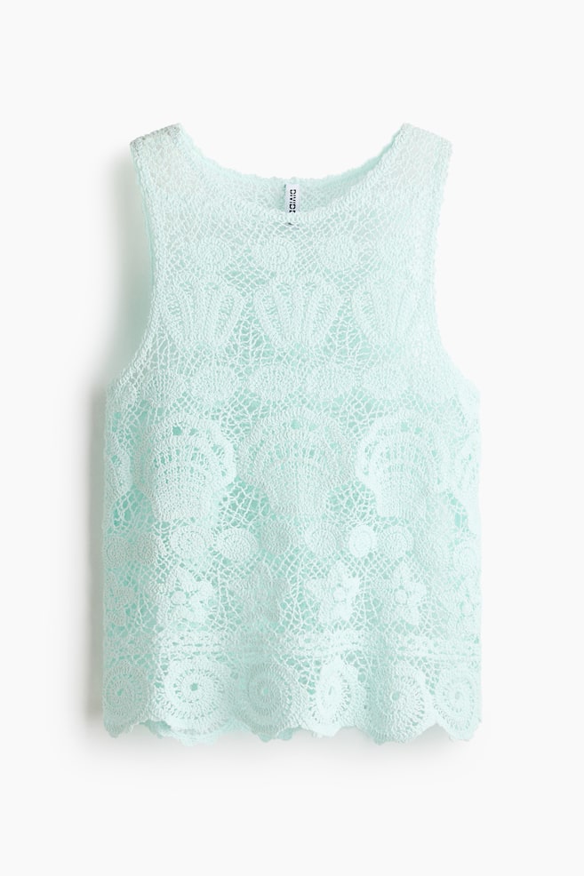 A pale aqua sleeveless top is presenting its front, featuring an intricate crochet pattern. It is designed with a round neckline and a scalloped hem. - 1