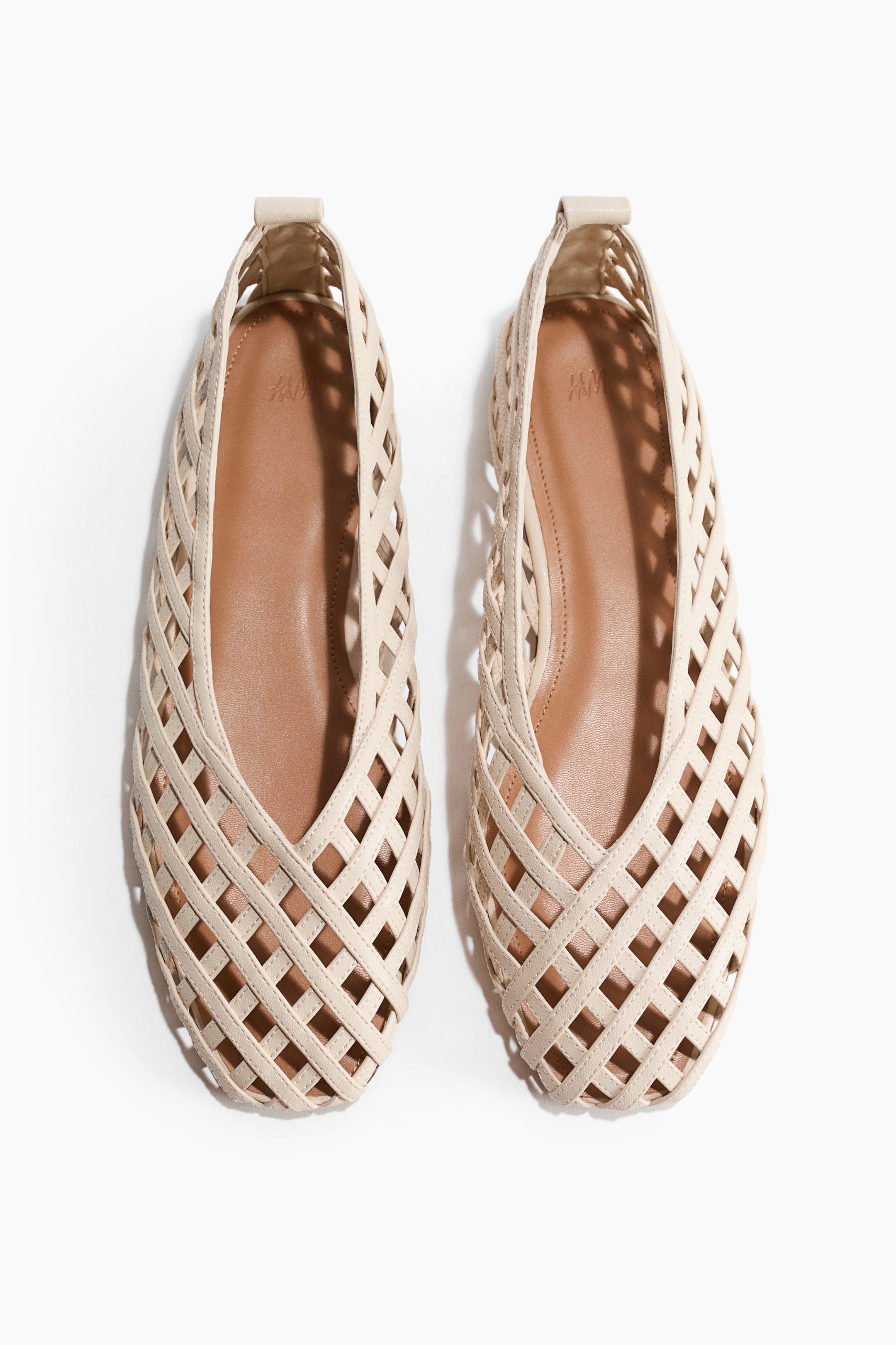 View larger image: Ballet flats showcase a light beige woven lattice design with round toes, presented from the front, featuring brown inner soles.