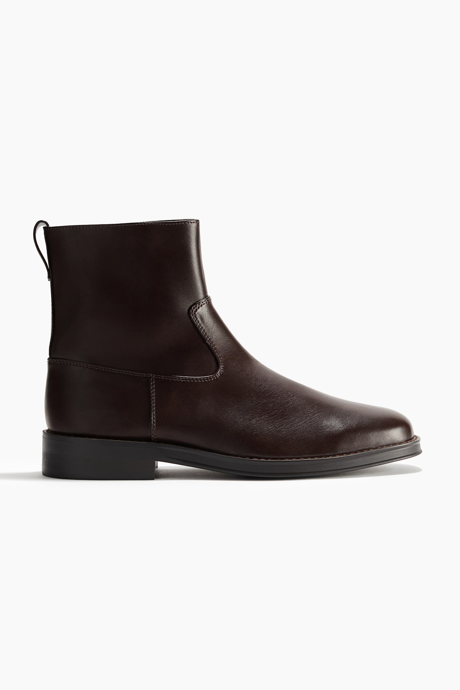 A dark brown leather ankle boot is shown in profile facing right, featuring a round toe, a low block heel, and a pull loop at the back. The boot has a smooth finish with neat stitched seams along the side and heel.