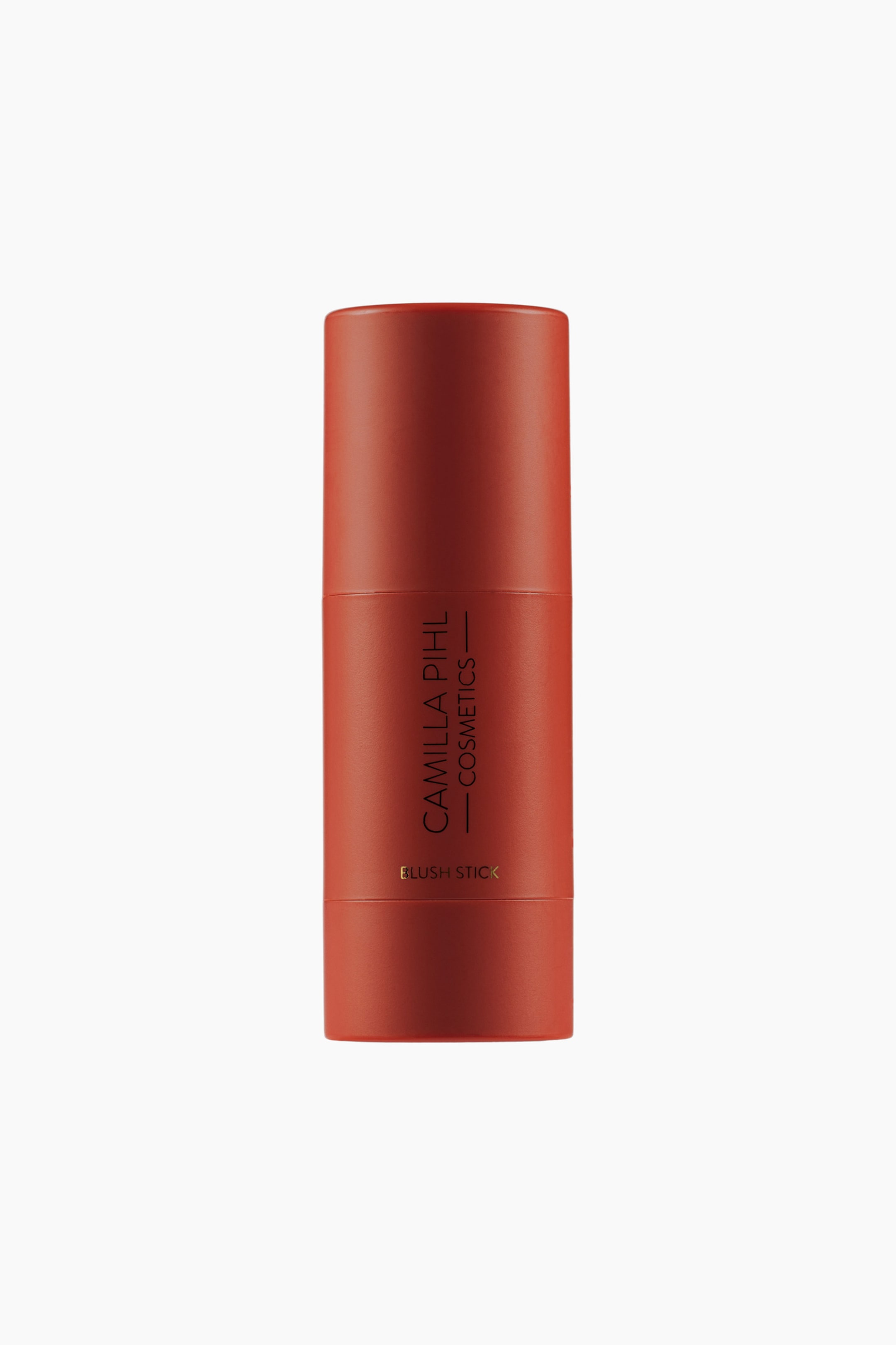 Visa större bild: En cylindrisk rödbrun rouge-sticka står upprätt, vänd framåt, med "CAMILLA PIHL COSMETICS" skrivet vertikalt och "BLUSH STICK" horisontellt i en mörkare ton.