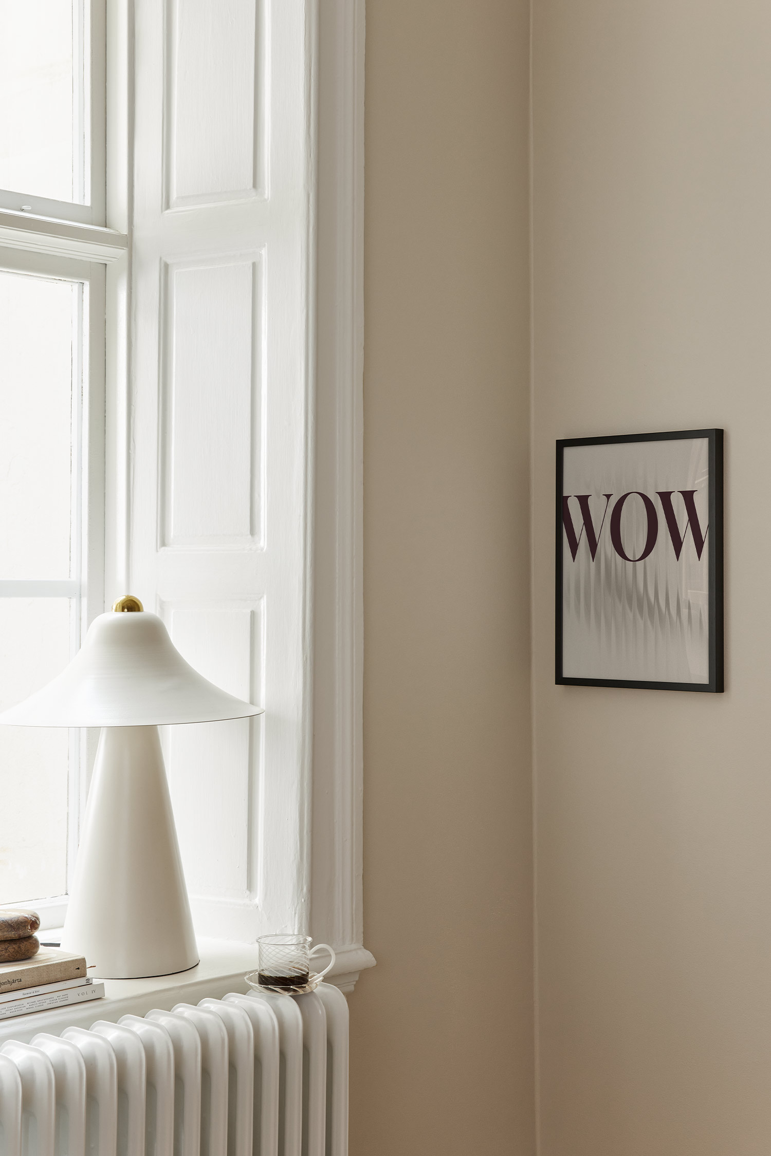 Et rektangulært kunsttryk viser ordet "WOW" i en fed, mørkebrun serif-skrifttype. Teksten er lagt oven på en lysebeige, kornet baggrund med lodrette, bølgende forvrængninger, der løber ned gennem midten.