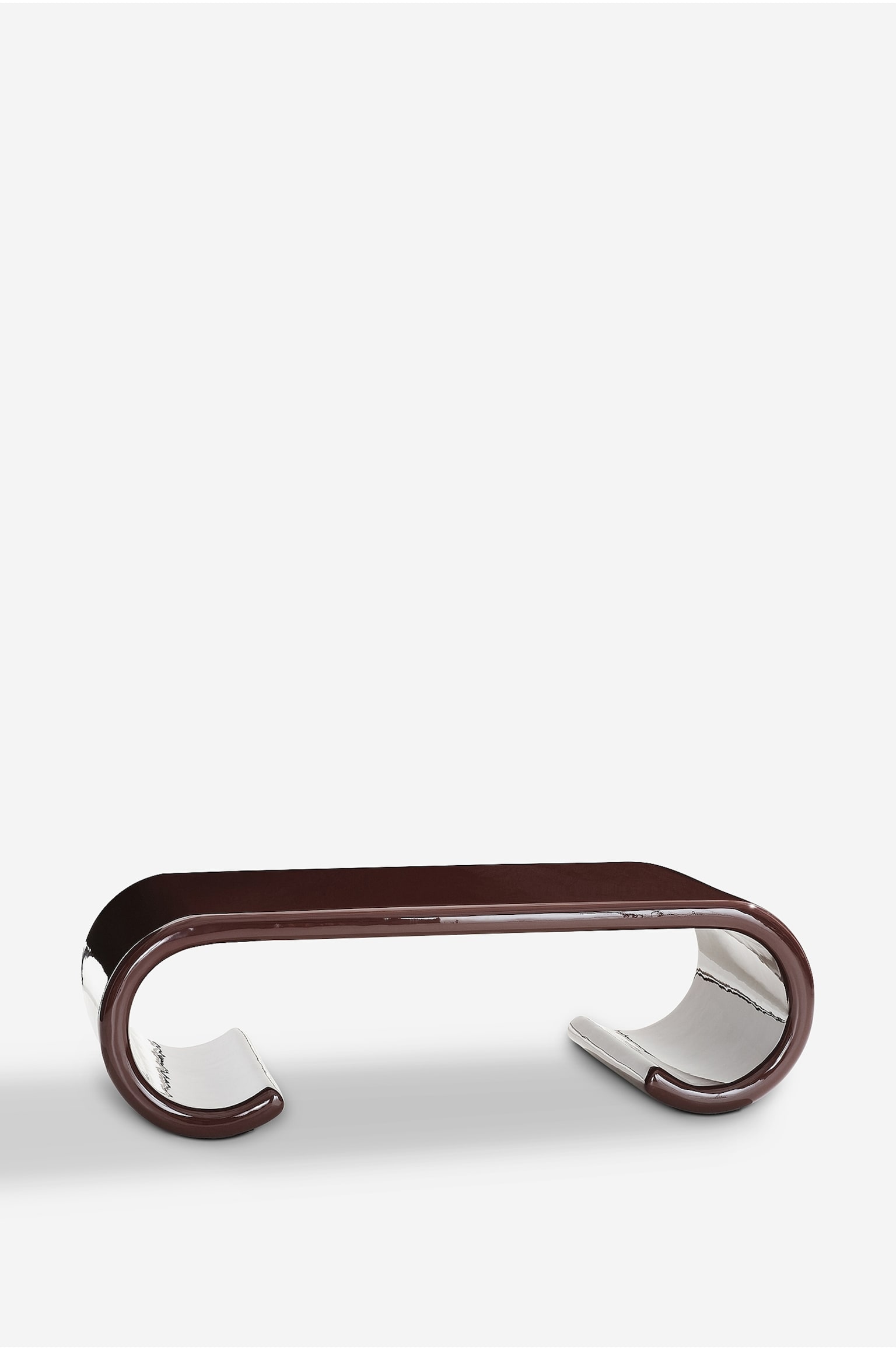 Ett modernt soffbord visar en skulptural design i en högblank, djupt rödbrun finish. Det har en plan bordsskiva som mjukt böjer sig nedåt på båda sidor och övergår i inåtböjda, scrollformade ben. Den mycket reflekterande ytan framhäver bordets sammanhängande, flytande form från en lätt vinklad framifrånvy. - 1