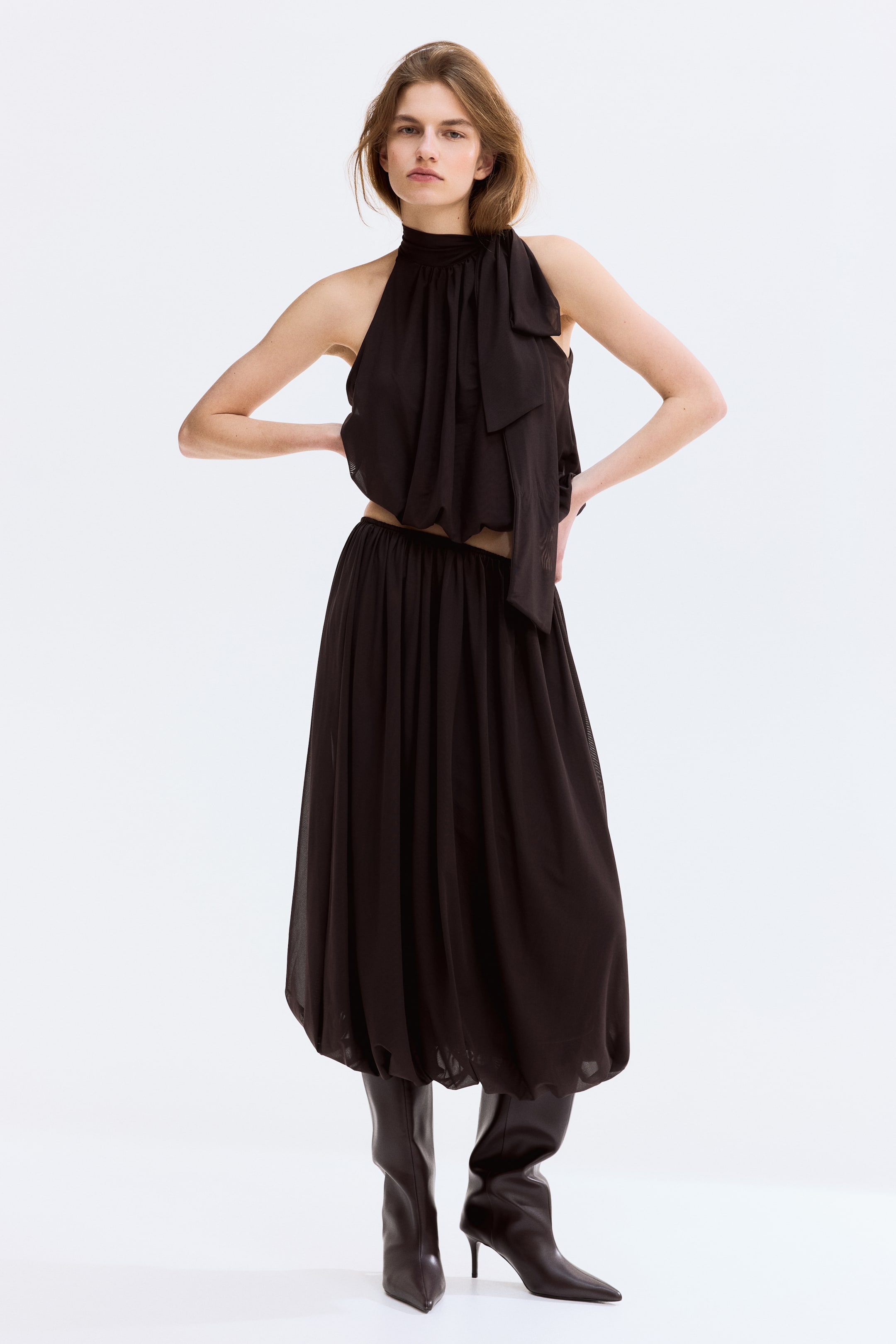 View larger image: The model is wearing an ankle-length, loose-fit skirt in mesh, featuring an elasticated waist and a bubble hem for a puffy silhouette.