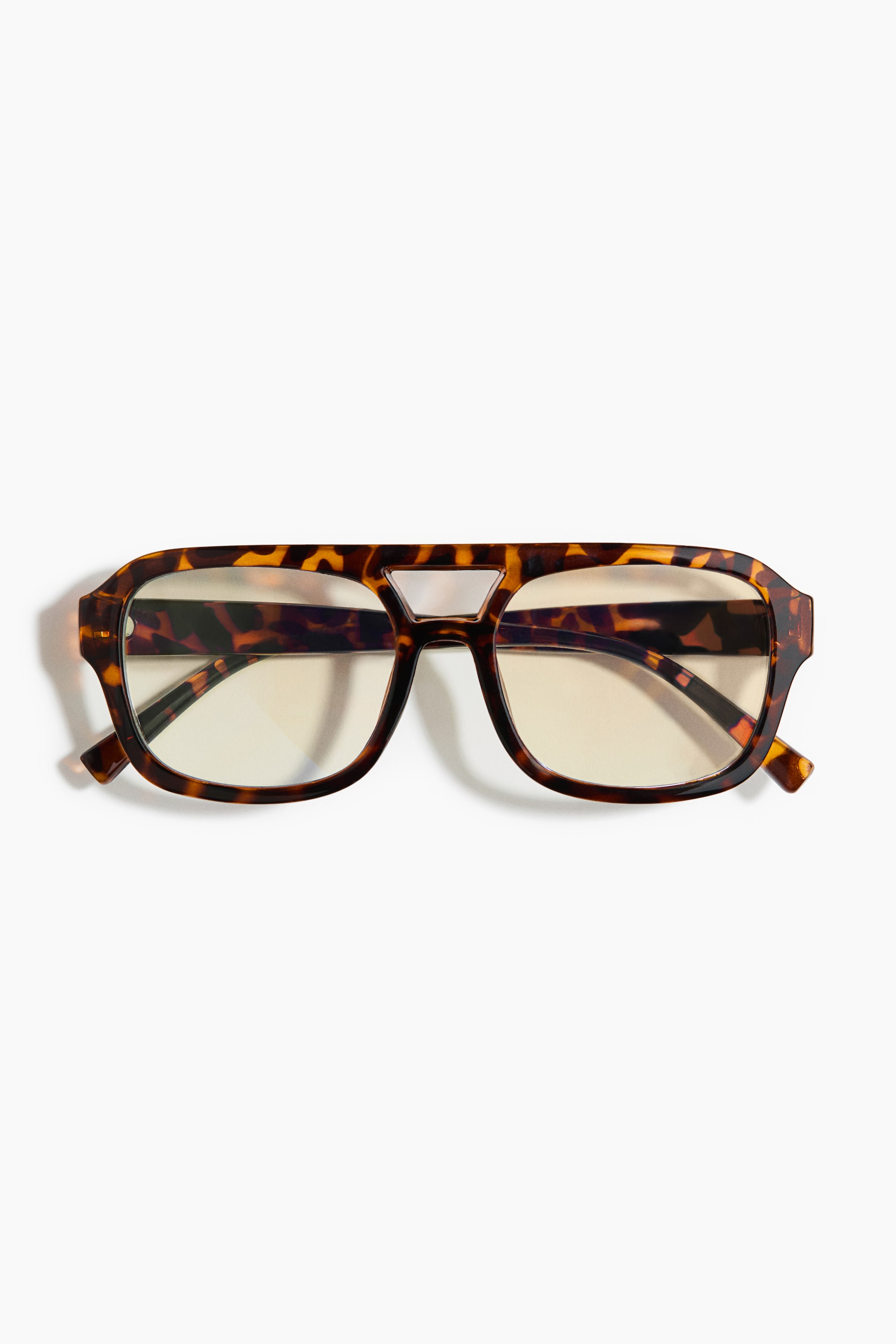 View larger image: Glasses feature a tortoiseshell frame with a double bridge, presenting a rectangular shape with rounded corners when viewed from the front. The lenses appear clear with a slight yellowish tint.