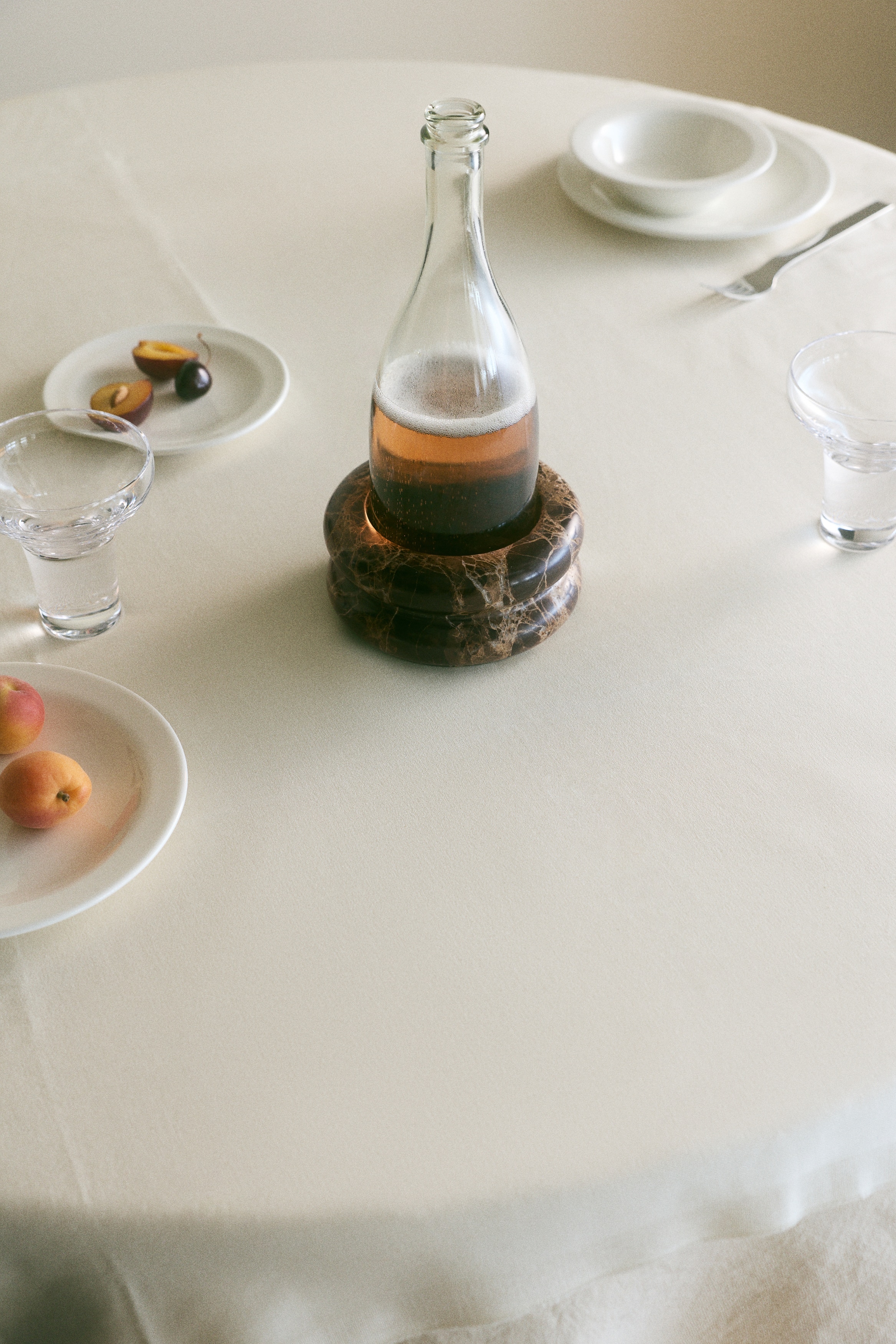 A brown marble bowl showcases a rounded, contoured shape with a central indentation. It features intricate white and light brown veining across its entire surface.