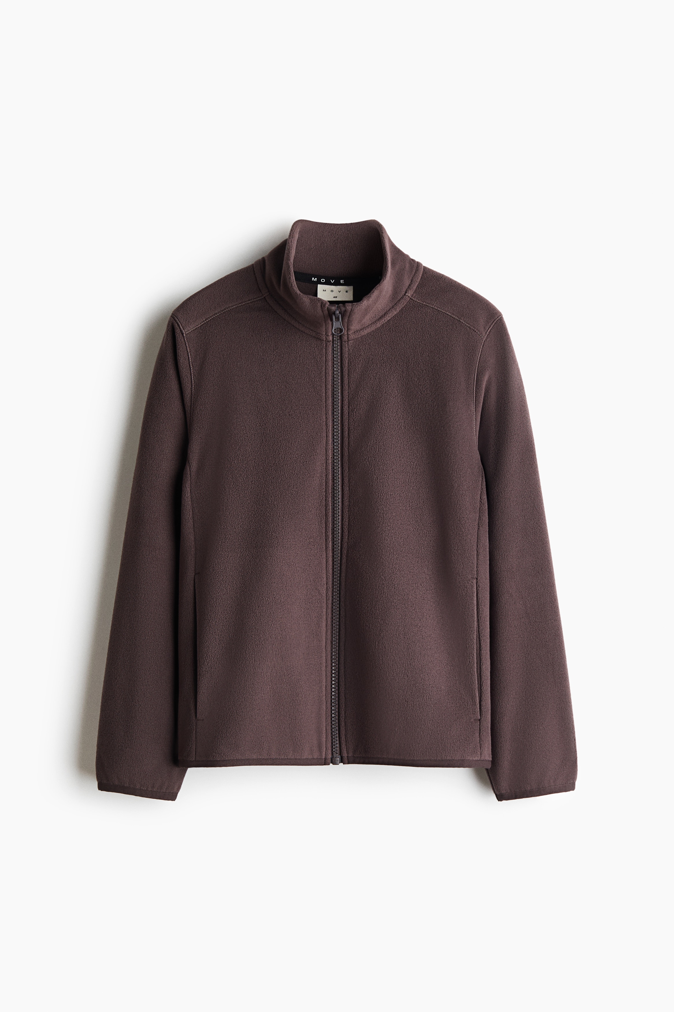A dark brown fleece sports jacket is shown from the front, featuring a high stand-up collar, a full-length front zip, and elasticated binding at the cuffs and hem. The jacket is worn over a black T-shirt and paired with matching fleece trousers.